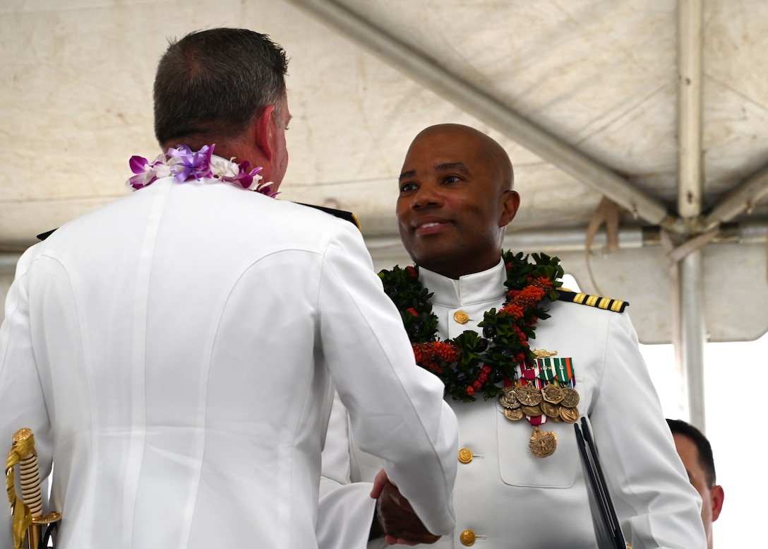 Rear Adm. Brendan C. McPherson (left), deputy commander of U.S. Coast Guard Pacific Area, shakes hands with Capt. Willie Carmichael (right) during the U.S. Coast Guard Cutter Midgett’s (WMSL 757) change of command ceremony on Coast Guard Base Honolulu, July 20, 2023. McPherson presided over the ceremony in which Capt. Matthew Rooney relieved Carmichael as Midgett’s commanding officer. U.S. Coast Guard photo by Chief Petty Officer Matthew Masaschi.