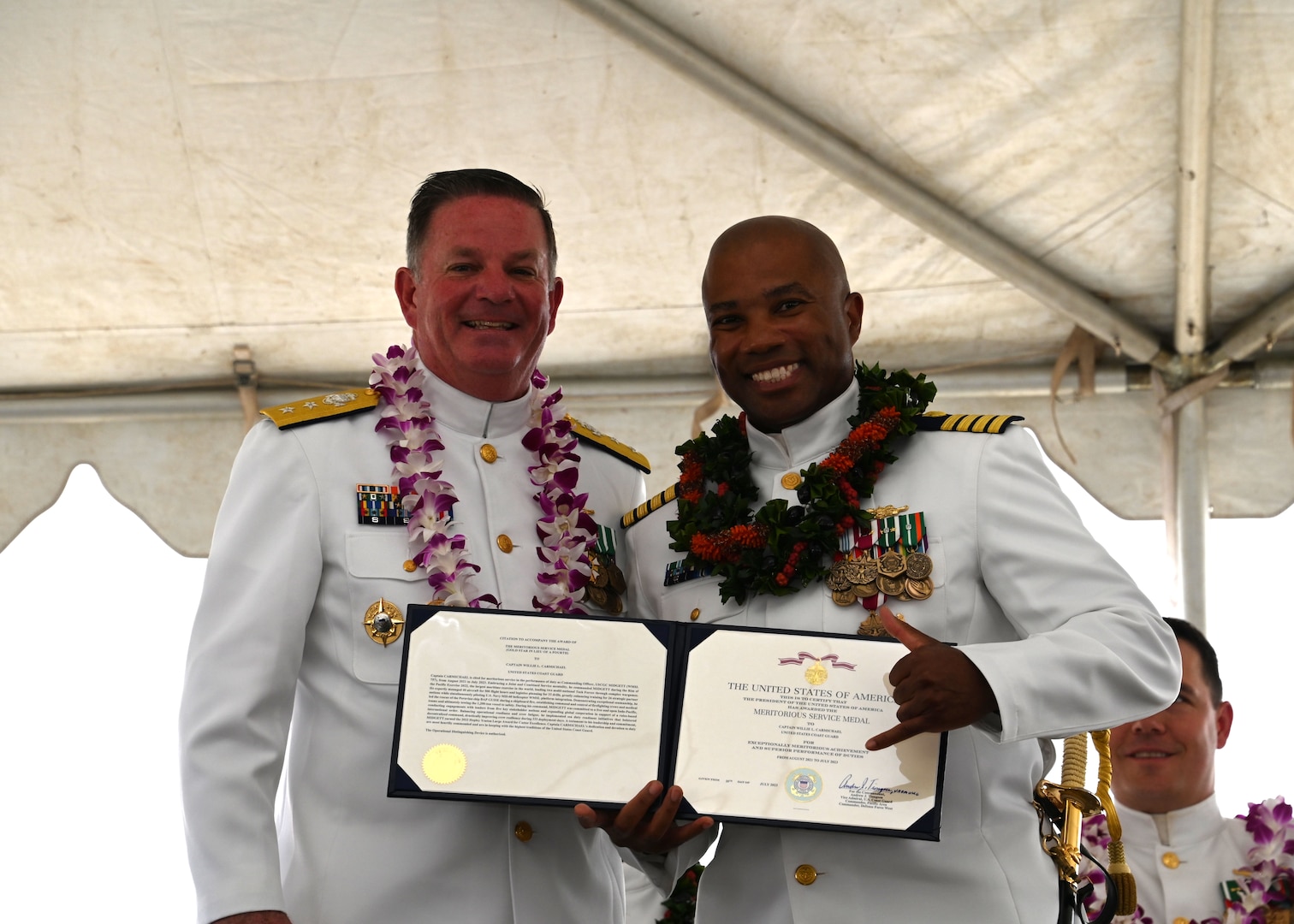 Rear Adm. Brendan C. McPherson (left), deputy commander of U.S. Coast Guard Pacific Area, presents Capt. Willie Carmichael (right) a meritorious service medal during the U.S. Coast Guard Cutter Midgett’s (WMSL 757) change of command ceremony on Coast Guard Base Honolulu, July 20, 2023. McPherson presided over the ceremony in which Capt. Matthew Rooney relieved Carmichael as Midgett’s commanding officer. U.S. Coast Guard photo by Chief Petty Officer Matthew Masaschi.