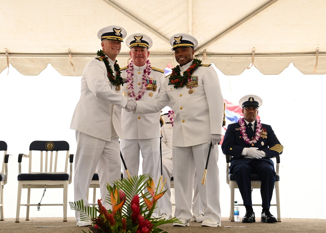 Capt. Matthew Rooney (left) and Capt. Willie Carmichael (right) shake hands during the U.S. Coast Guard Cutter Midgett’s (WMSL 757) change of command ceremony on Coast Guard Base Honolulu, July 20, 2023. Rear Adm. Brendan C. McPherson (center), deputy commander of U.S. Coast Guard Pacific Area, presided over the ceremony in which Rooney relieved Carmichael as Midgett’s commanding officer. U.S. Coast Guard photo by Chief Petty Officer Matthew Masaschi.