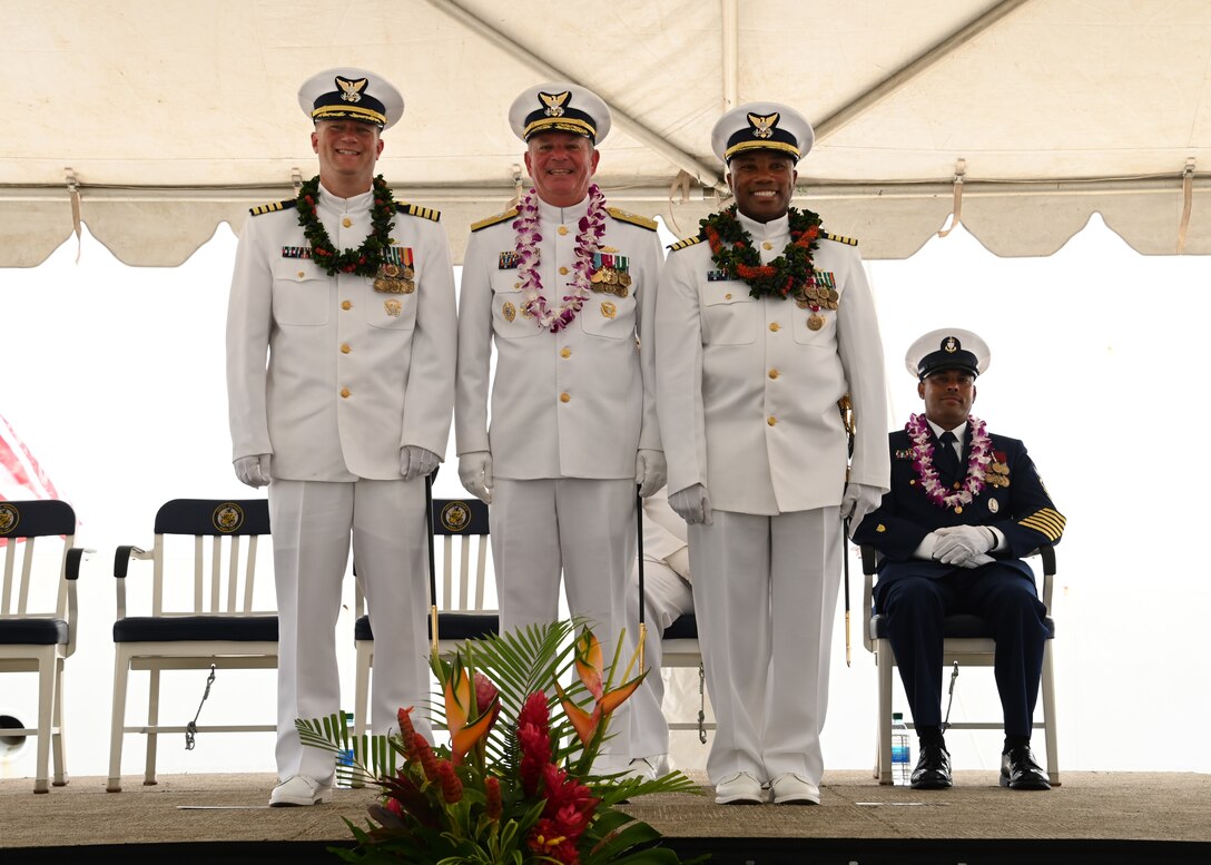 Capt. Matthew Rooney (left) stands alongside Rear Adm. Brendan C. McPherson (center), deputy commander of U.S. Coast Guard Pacific Area, and Capt. Willie Carmichael (right) during the U.S. Coast Guard Cutter Midgett’s (WMSL 757) change of command ceremony on Coast Guard Base Honolulu, July 20, 2023. McPherson presided over the ceremony in which Rooney relieved Carmichael as Midgett’s commanding officer. U.S. Coast Guard photo by Chief Petty Officer Matthew Masaschi.