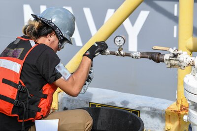 Naval Supply Systems Command Fleet Logistics Center Pearl Harbor employee Lawsen Lee, fuel distribution system worker, pours a sample of F76 marine diesel fuel during an unpacking operation onboard Joint Base Pearl Harbor-Hickam (JBPHH), Hawaii, Oct. 27, 2022. The unpacking operation will remove approximately one million gallons of fuel from three primary fuel pipelines connecting the Red Hill Bulk Fuel Storage Facility (RHBFSF) to fuel points on JBPHH. JTF-RH was established by the Department of Defense to ensure the safe and expeditious defueling of the RHBFSF. (U.S. Marine Corps photo by Cpl. Luke Cohen)
