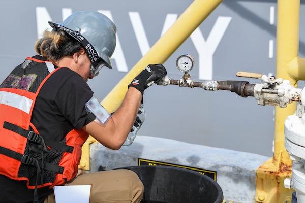 Naval Supply Systems Command Fleet Logistics Center Pearl Harbor employee Lawsen Lee, fuel distribution system worker, pours a sample of F76 marine diesel fuel during an unpacking operation onboard Joint Base Pearl Harbor-Hickam (JBPHH), Hawaii, Oct. 27, 2022. The unpacking operation will remove approximately one million gallons of fuel from three primary fuel pipelines connecting the Red Hill Bulk Fuel Storage Facility (RHBFSF) to fuel points on JBPHH. JTF-RH was established by the Department of Defense to ensure the safe and expeditious defueling of the RHBFSF. (U.S. Marine Corps photo by Cpl. Luke Cohen)