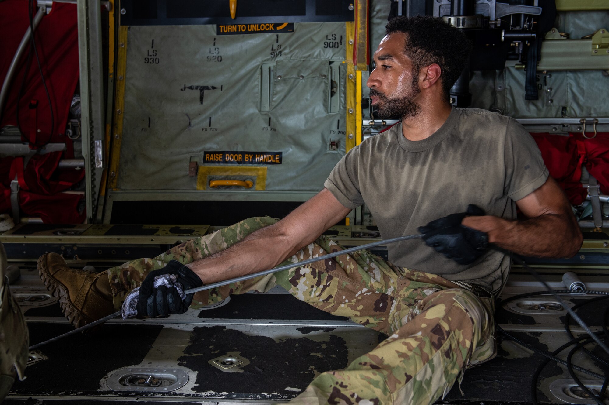 An Airman inspects a cargo wench aboard a C-130J