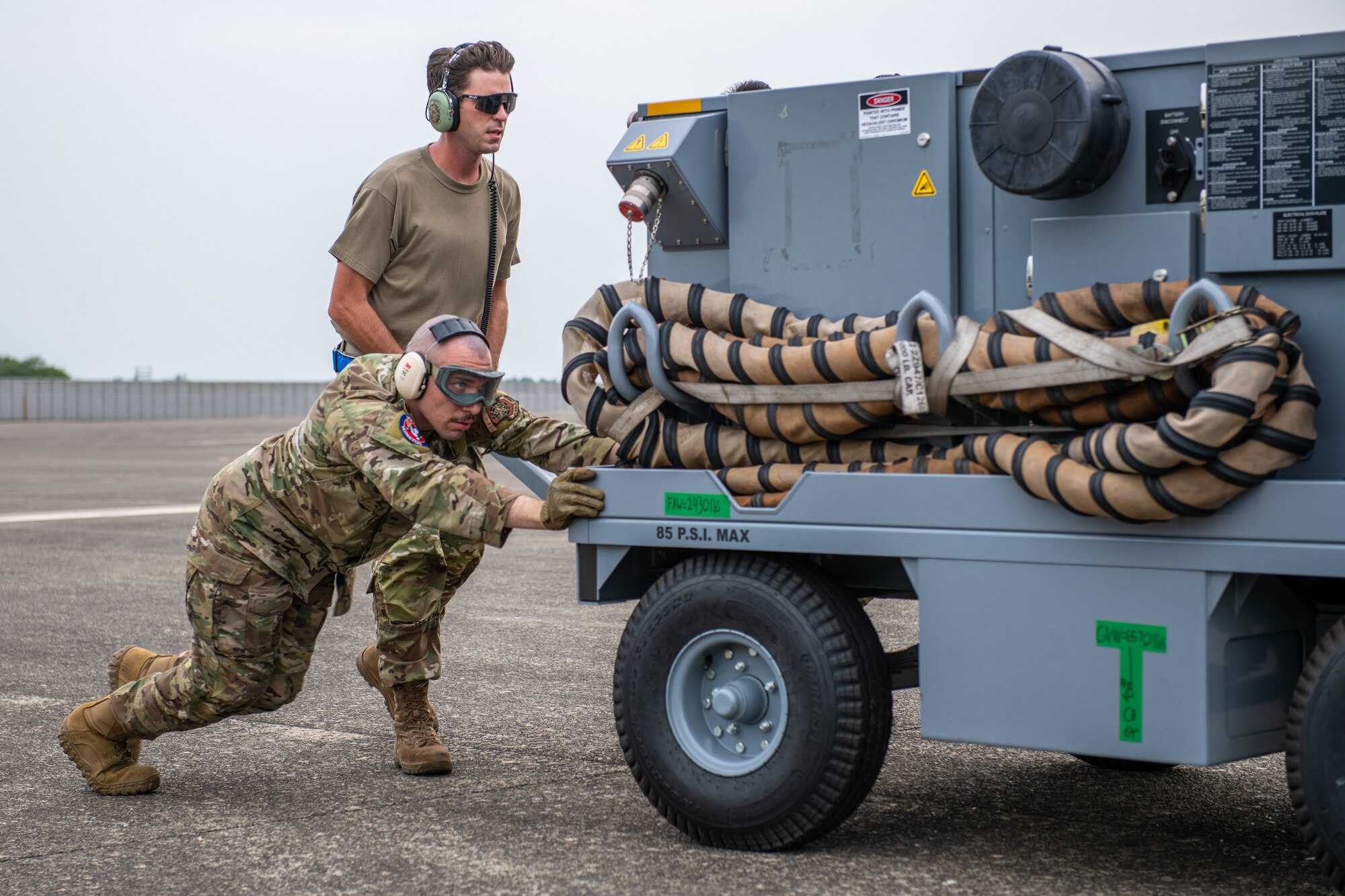 Airman pushes a mobile air conditioner