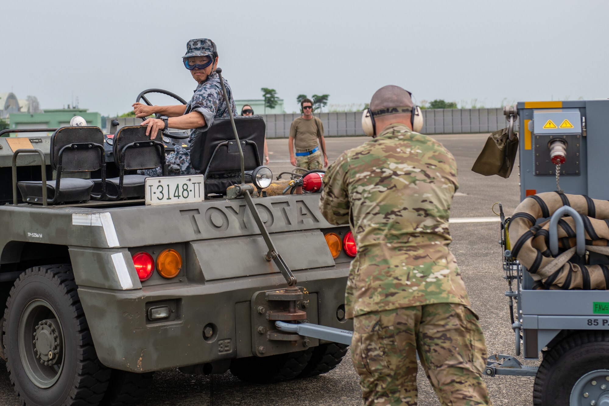Airmen work together to guide a mobile air conditioner