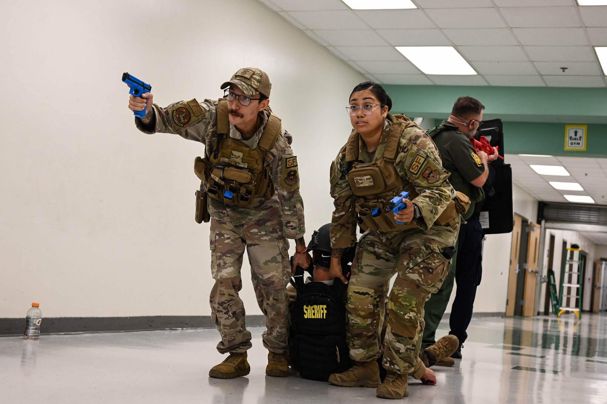 U.S. Air Force Staff Sgt. Anthony Zayas (left), 47th Security Forces Squadron flight sergeant, and Staff Sgt. Siree Mooney (right), 47th SFS flight sergeant, drag a simulated victim during a training exercise created by the Val Verde Sheriff's Office at San Felipe Memorial Middle School, Texas, July 12, 2023.