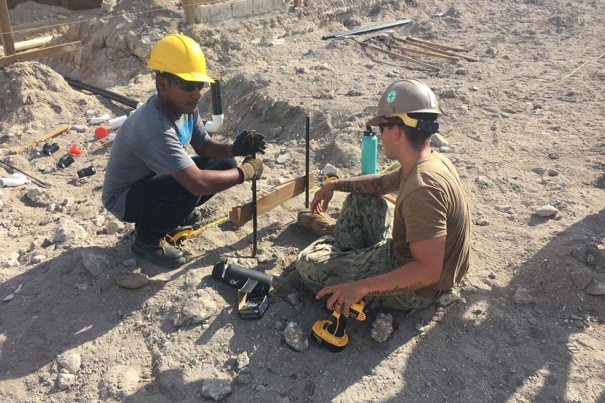 Two men work on a construction site.