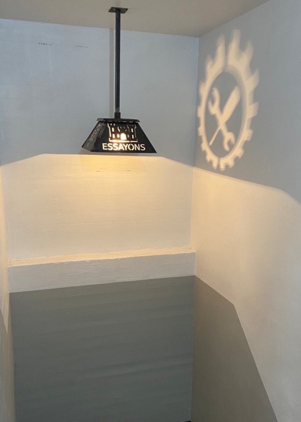 A custom “Essayons” light fixture in a hallway is pictured.