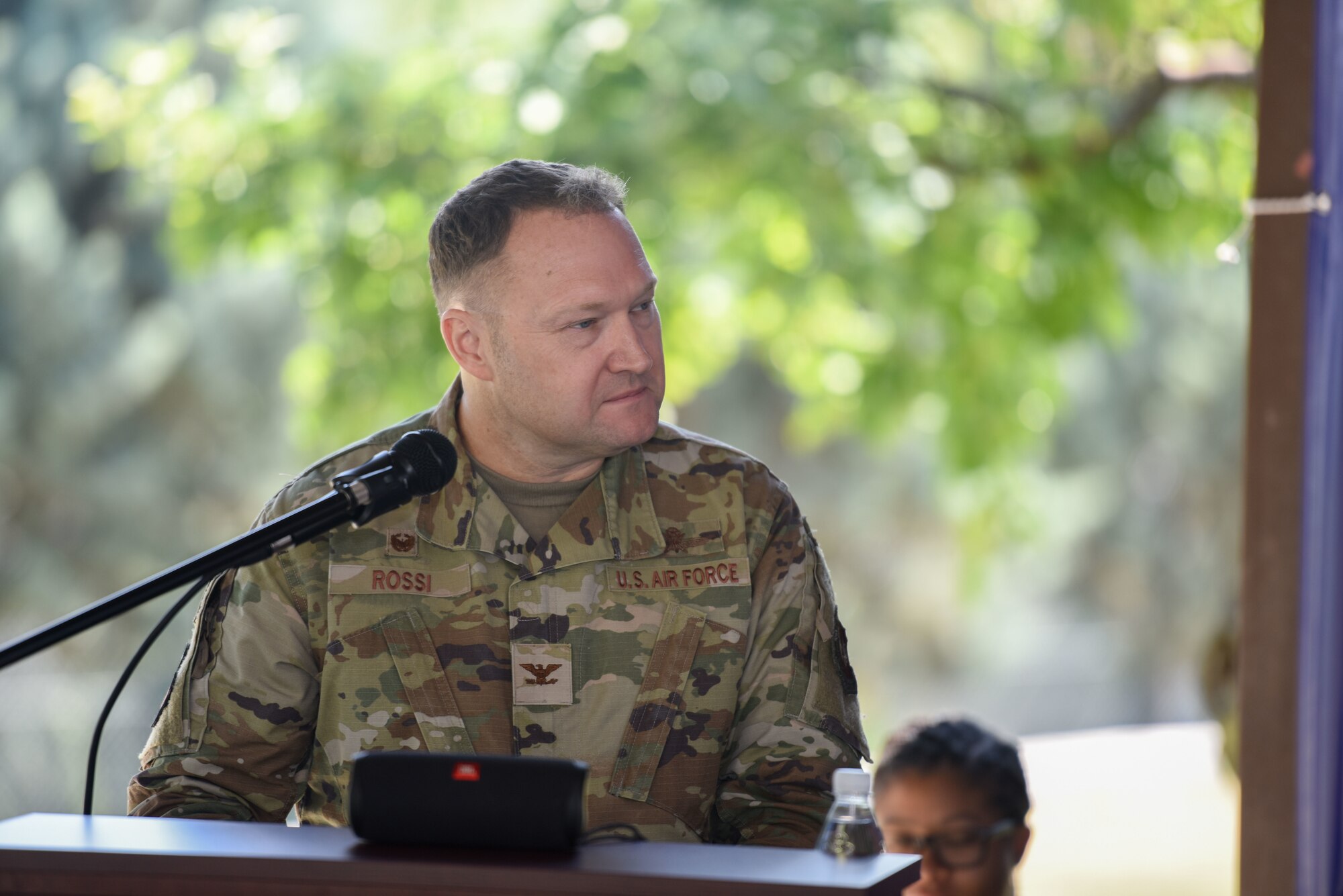 A man in uniform speaks into a microphone.