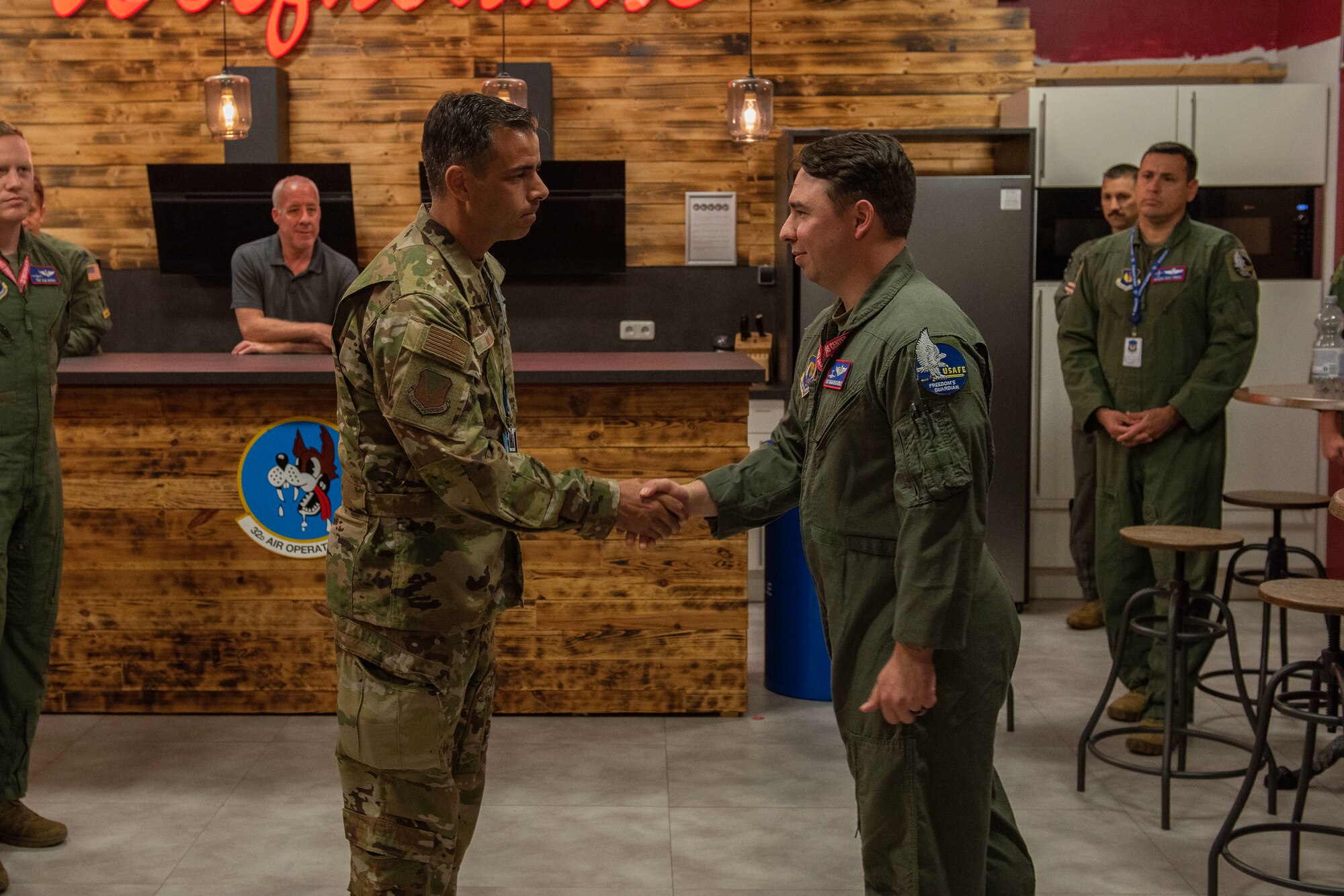 U.S. Air Force Tech. Sgt. Kagan Weatherly, right, 603rd Air Operations Center airlift plans noncommissioned officer in charge, accepts a coin from Col. Jamil Musa, left, 86th Airlift Wing vice commander, at Ramstein Air Base, Germany, July 20, 2023. Weatherly was awarded Airlifter of the Week for his efforts in his work center such as planning C-130 missions supporting the U.S. European and African Commands, overseeing multiple NATO readiness exercises including Finland’s first exercise as a NATO member, and ensuring more than 400 Airmen in his squadron are fit to fight as a primary unit fitness program manager. (U.S. Air Force photo by Senior Airman Madelyn Keech)