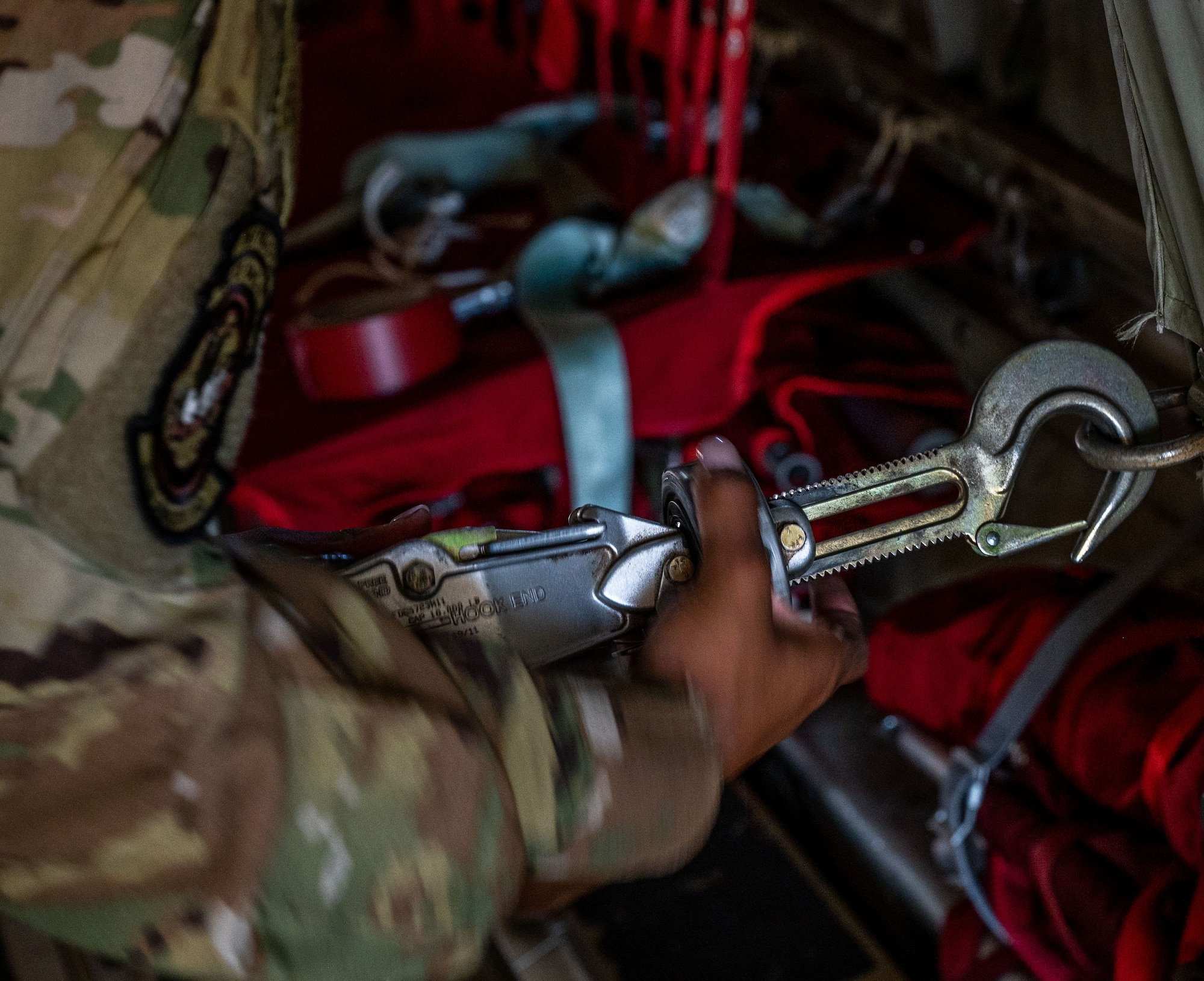 An Airman tightens a cargo restraint