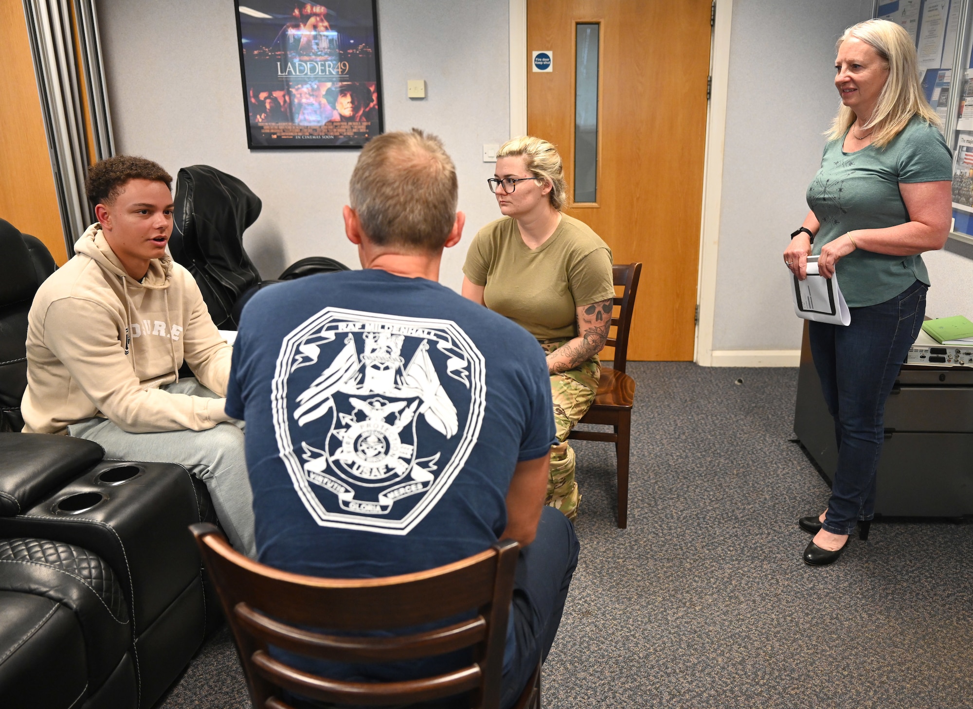 U.S. Air Force Airmen and British civilians from the 100th Civil Engineer Squadron Fire Department and 100th Security Forces Squadron interact during a role play session during a Mental Health First Aider course as Maj. Pauline Murray-Knight MBE, right, MHFA national trainer, listens to their responses at Royal Air Force Mildenhall, England, June 27, 2023. The two-day course was taught to first responders to help provide them the knowledge and confidence to help assist someone experiencing a mental health breakdown, challenge or crisis that they may be responding to or involved with. Attendees were encouraged to wear civilian clothes and use first names only, to allow all ranks to talk freely with each other about the topics covered. (U.S. Air Force photo by Karen Abeyasekere)