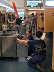 Students in Unit 5 troubleshooting galley equipment such as deep fat fryers, ranges, and ovens. (EMCS Jason Sardinas, EM school chief)