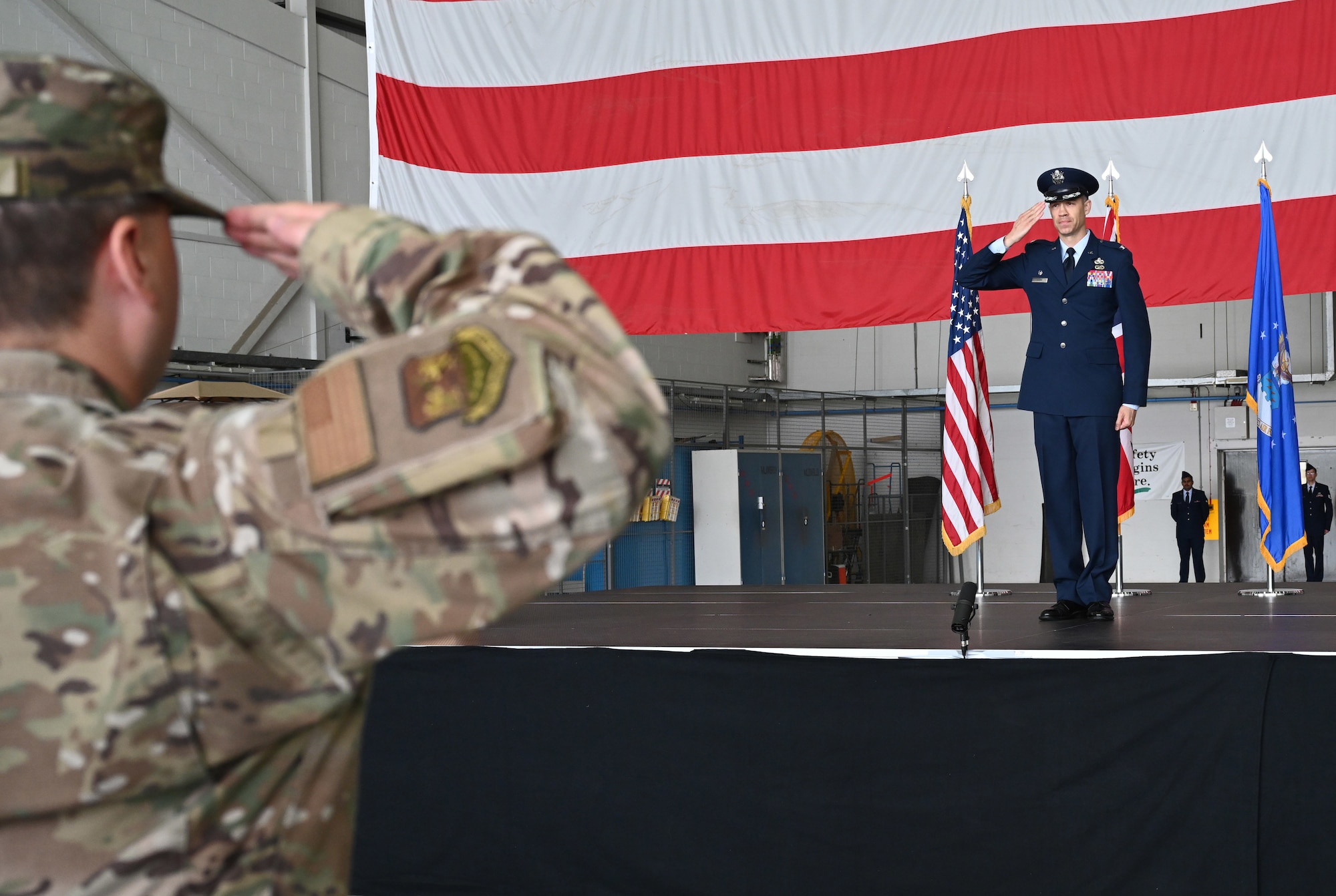 U.S. Air Force Col. Aaron Rivers, right, 100th Maintenance Group commander, presents his first salute to a formation of Airmen from the 100th MXG at his change of command ceremony at Royal Air Force Mildenhall, England, July 14, 2023. Rivers joins Team Mildenhall from Hill Air Force Base. (U.S. Air Force photo by Karen Abeyasekere)