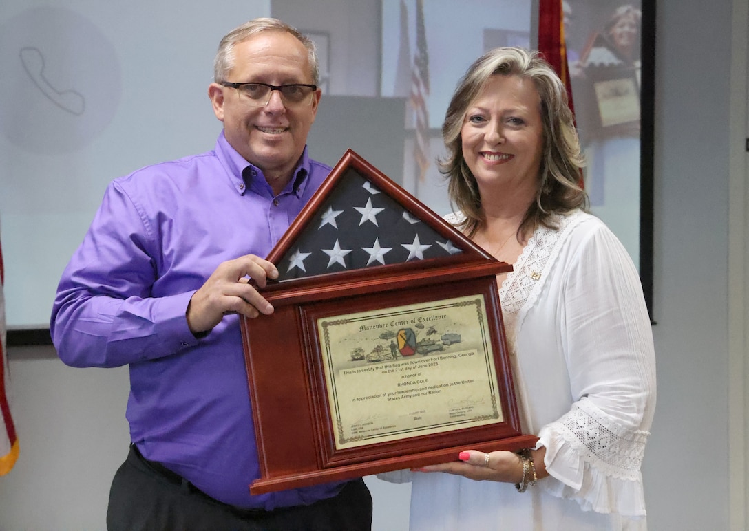 Rhonda Cole, U.S. Army Corps of Engineers, Mobile District CIO/G6 operations officer, receives her retirement flag from Donald Greenlee, Chief, Customer Requirements Division at her retirement ceremony at the Mobile District annex building Mobile, Alabama, July 14, 2023. Cole, who retired after 40 years of service in the federal government, plans to spend quality time with her family, friends and upcoming grandson and go on a South African Safari in during her retirement. (U.S. Army photo by Chuck Walker)