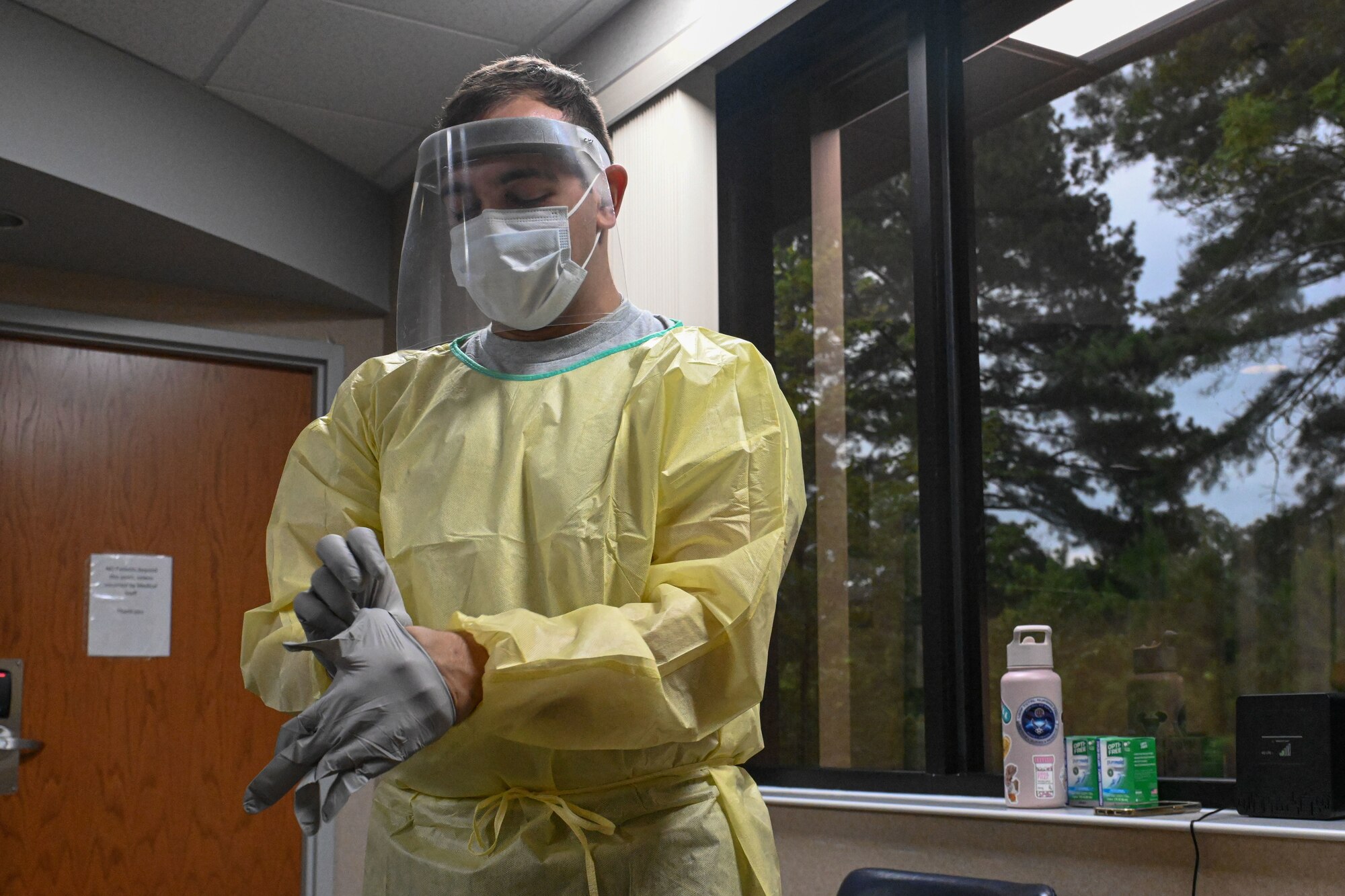 An Airman puts on personal protective equipment.