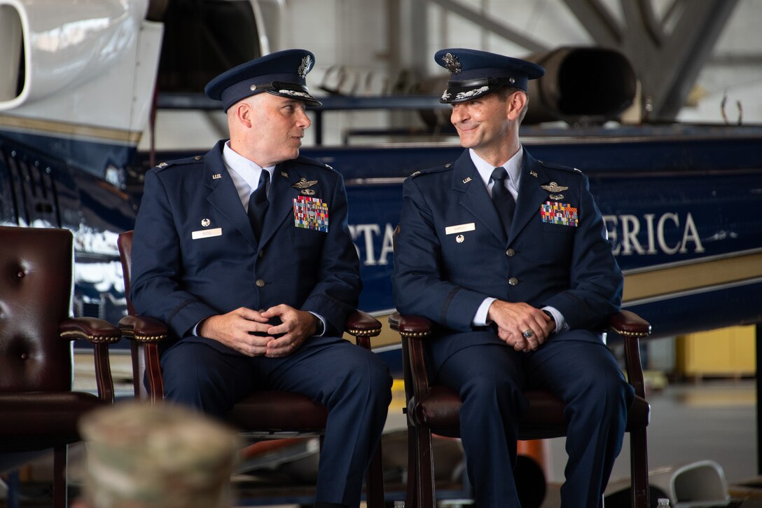 Two men in dress uniforms speak.