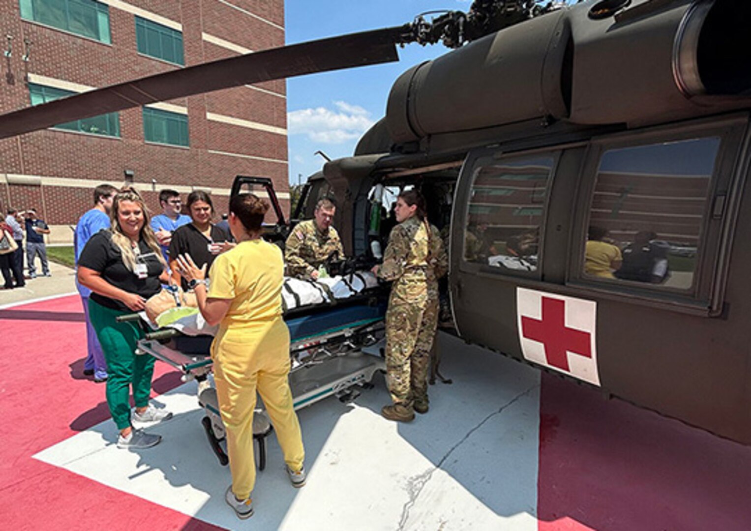 Aurora BayCare Medical Center professionals and Soldiers from the medevac assets of the Wisconsin Army National Guard’s 1st Battalion, 147th Aviation Regiment unload a mock patient from a UH-60 Black Hawk helicopter at Aurora BayCare Medical Center in Green Bay, Wis., June 22.