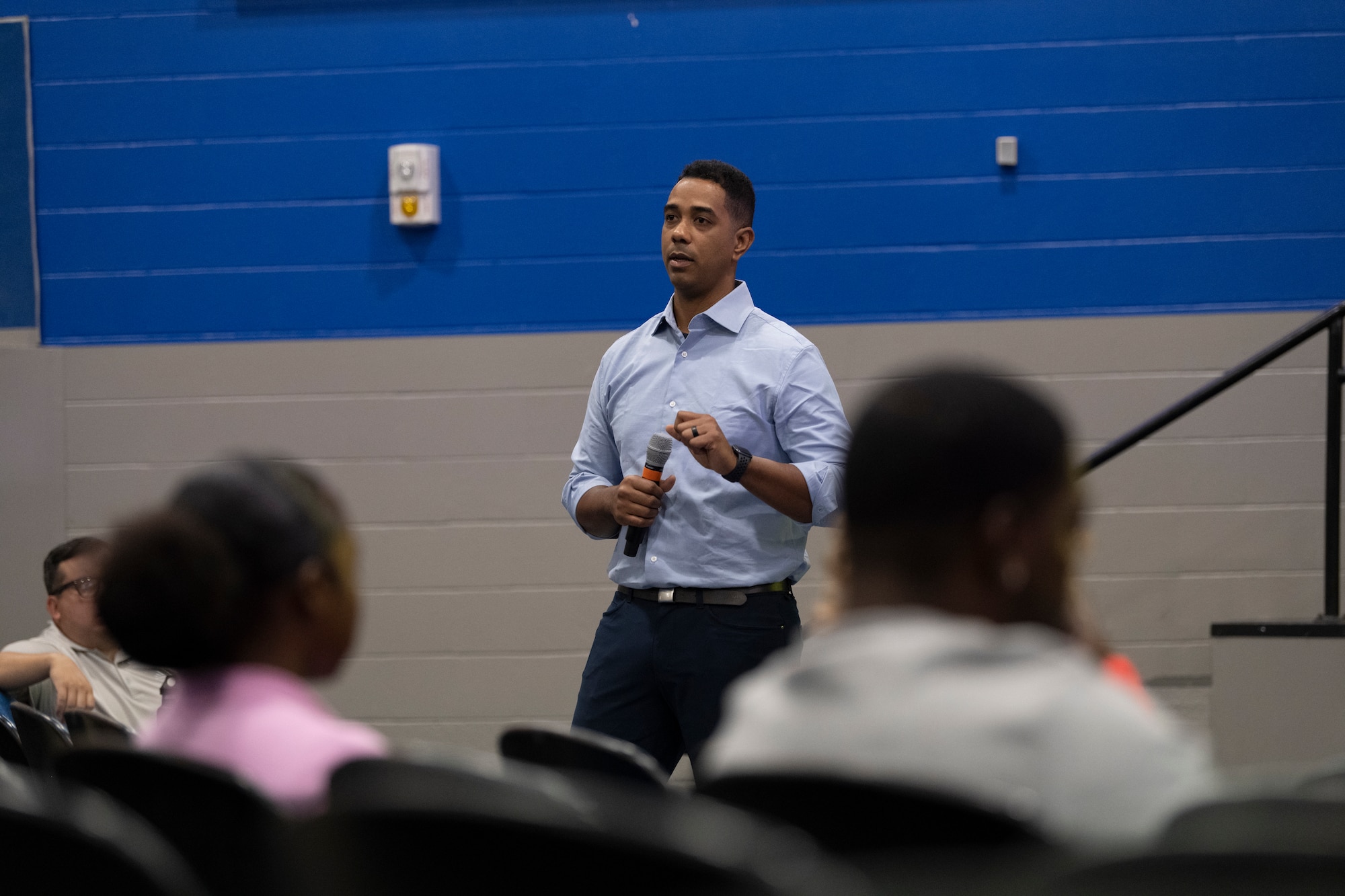 A photo of a man standing talking into a microphone