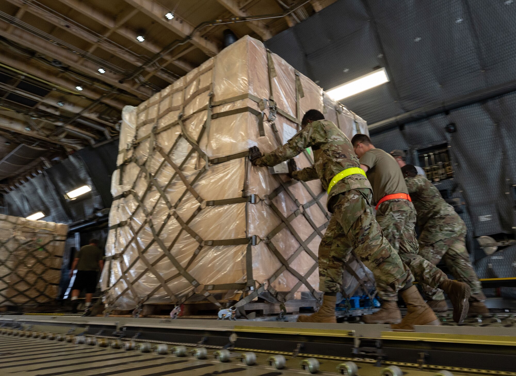 Team Dover Airmen load palletized cargo,  bound for Romania, onto a C-5M Super Galaxy during a foreign military sales mission at Dover Air Force Base, Delaware, June 27, 2023. The partnership between the United States and Romania is rooted in a shared commitment to democratic values, including the rule of law, open markets, respect for and the promotion of human rights. (U.S. Air Force photo by Senior Airman Cydney Lee)