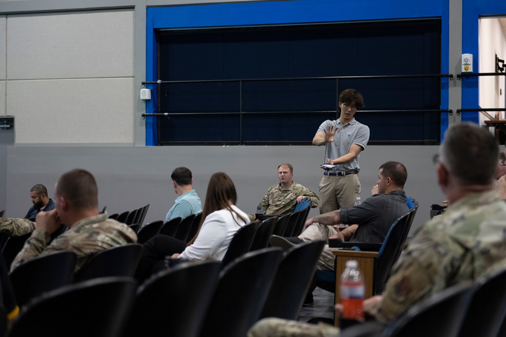 A photo of a person standing in an auditorium