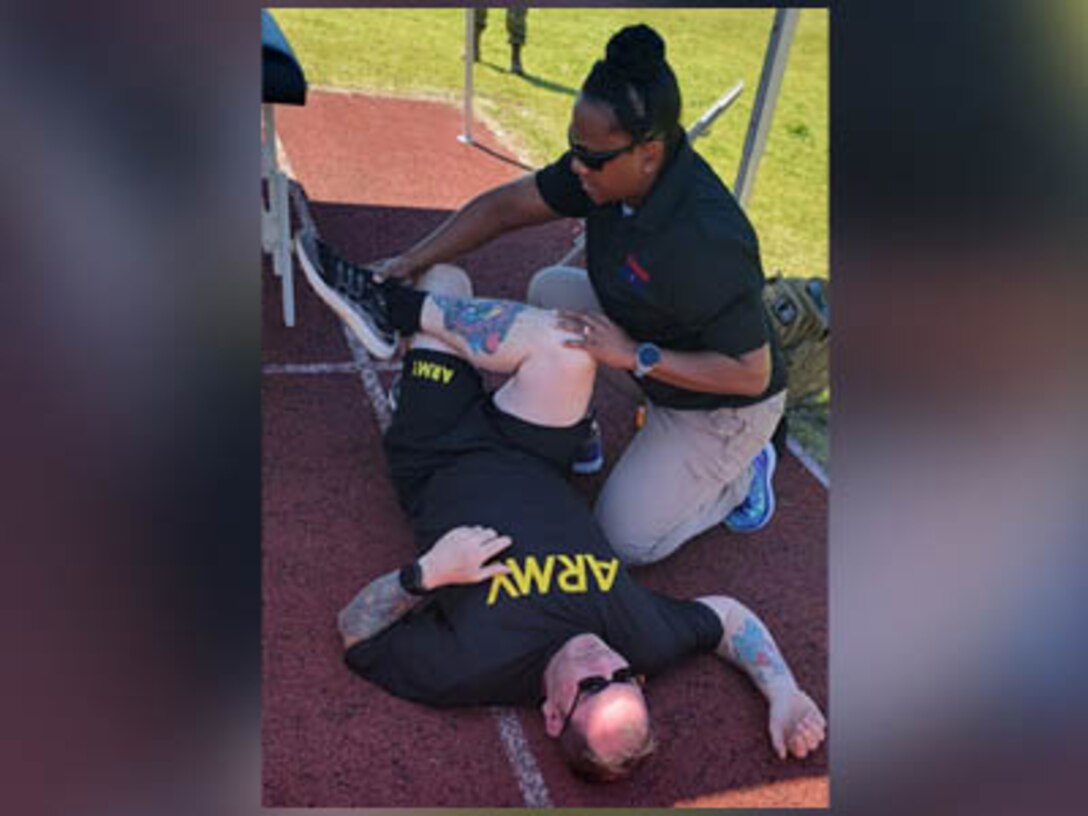 Dr. Yvonne Larochelle works with athletes on stretching at the 2023 Army Trials at Fort Liberty, N.C. in April 2023.