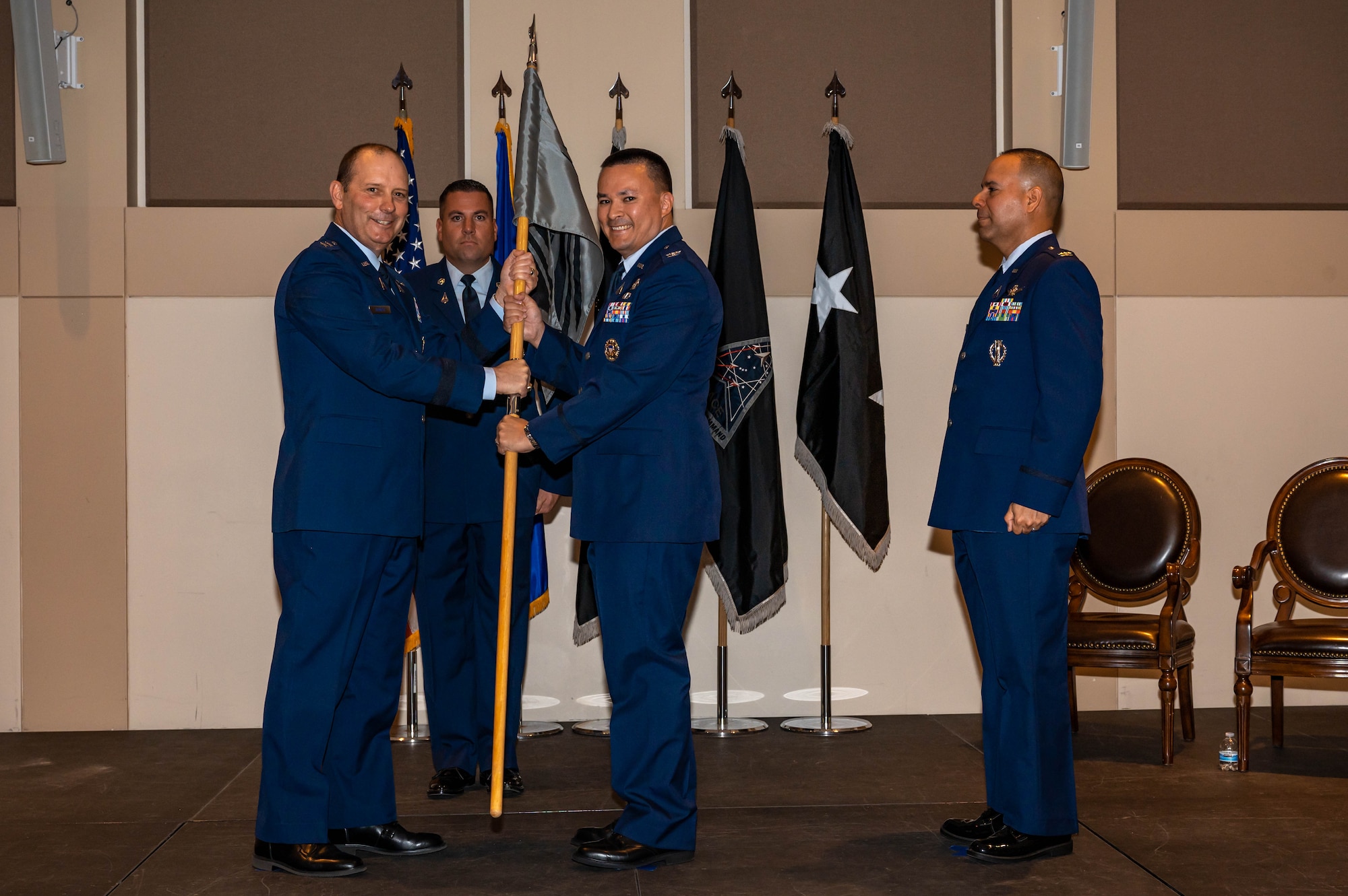 A man passes a guidon to another man.