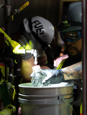 A quality assurance representative and fuel operators with Joint Task Force-Red Hill (JTF-RH), inspect a sample of fuel during dewatering at the Red Hill Bulk Fuel Storage Facility in Halawa, Hawaii, April 19, 2023. Dewatering removes the water from the fuel storage tanks. This is a routine task for maintenance of underground fuel storage tanks and is essential to prevent corrosion and protect fuel quality. Regulators from the Hawaii Department of Health and the Environmental Protection Agency are on site during dewatering. JTF-RH is committed to working with regulators, government officials, and stakeholders to ensure Red Hill is defueled safely, expeditiously and in compliance with all applicable laws and regulations. (DoD photo by U.S. Marine Corps Sgt. Luke Cohen)