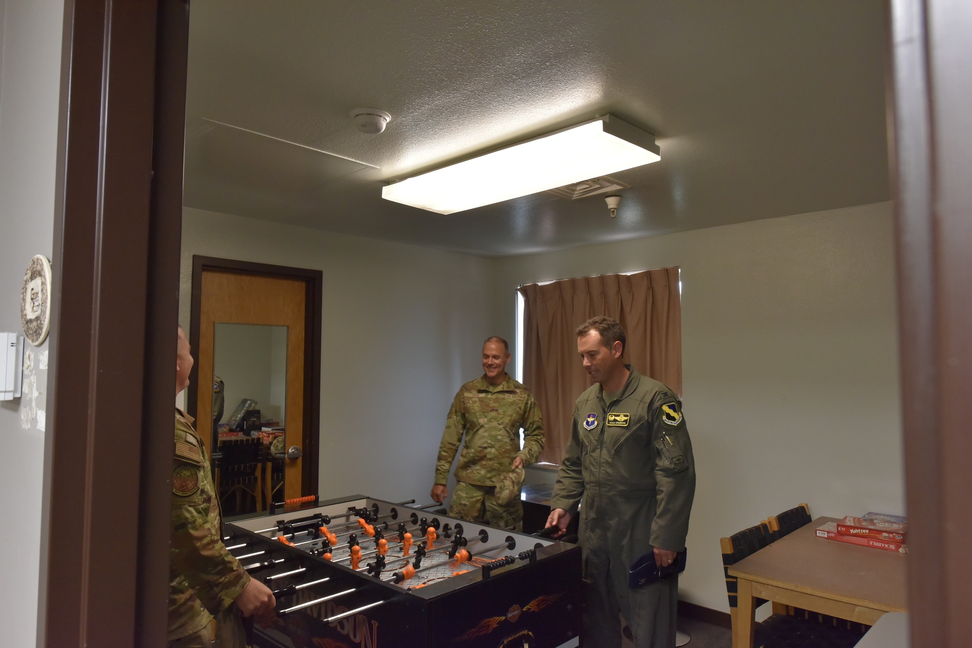 Air Force personnel look at a foosball table.
