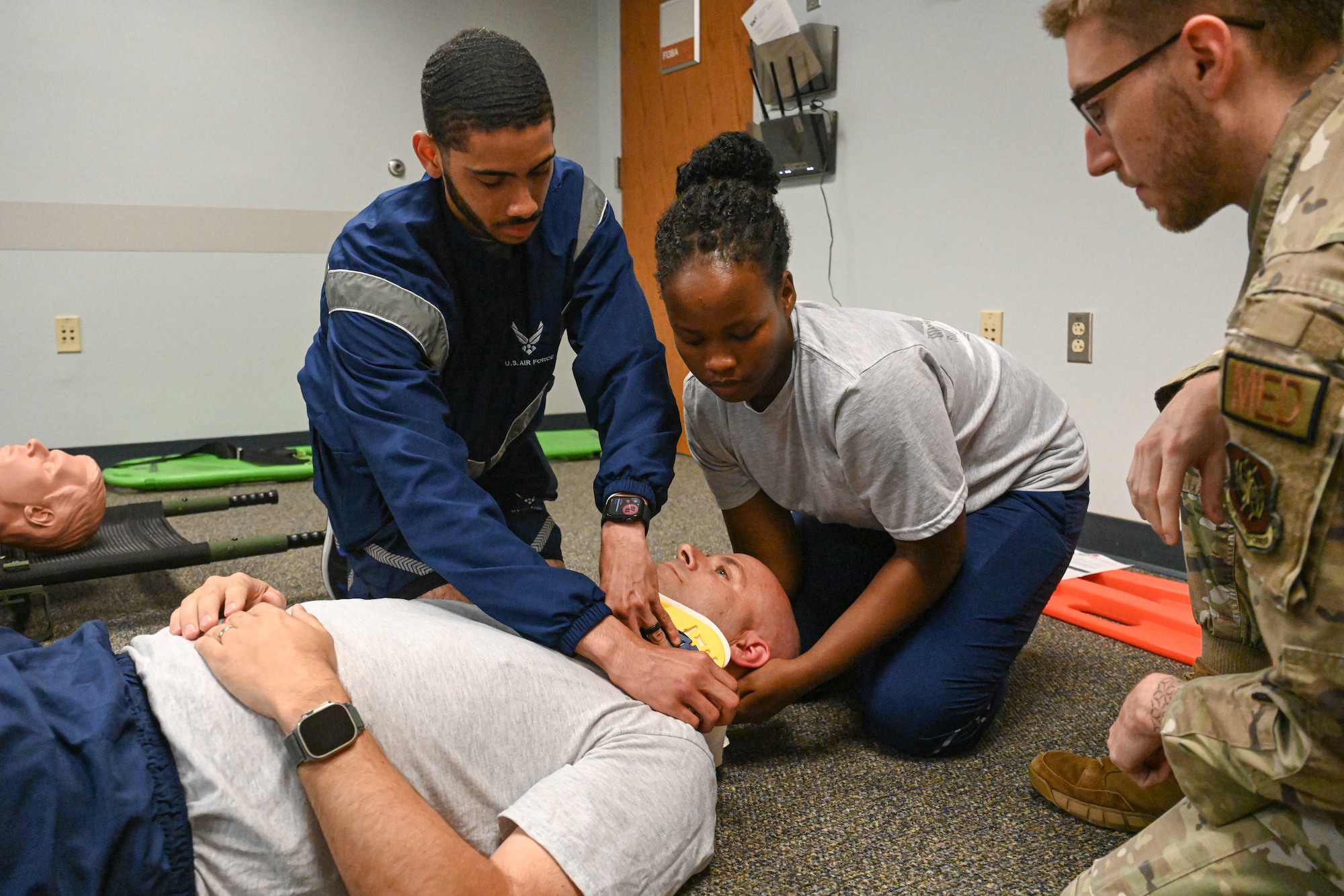 Airmen take care of a simulated patient with a neck injury.
