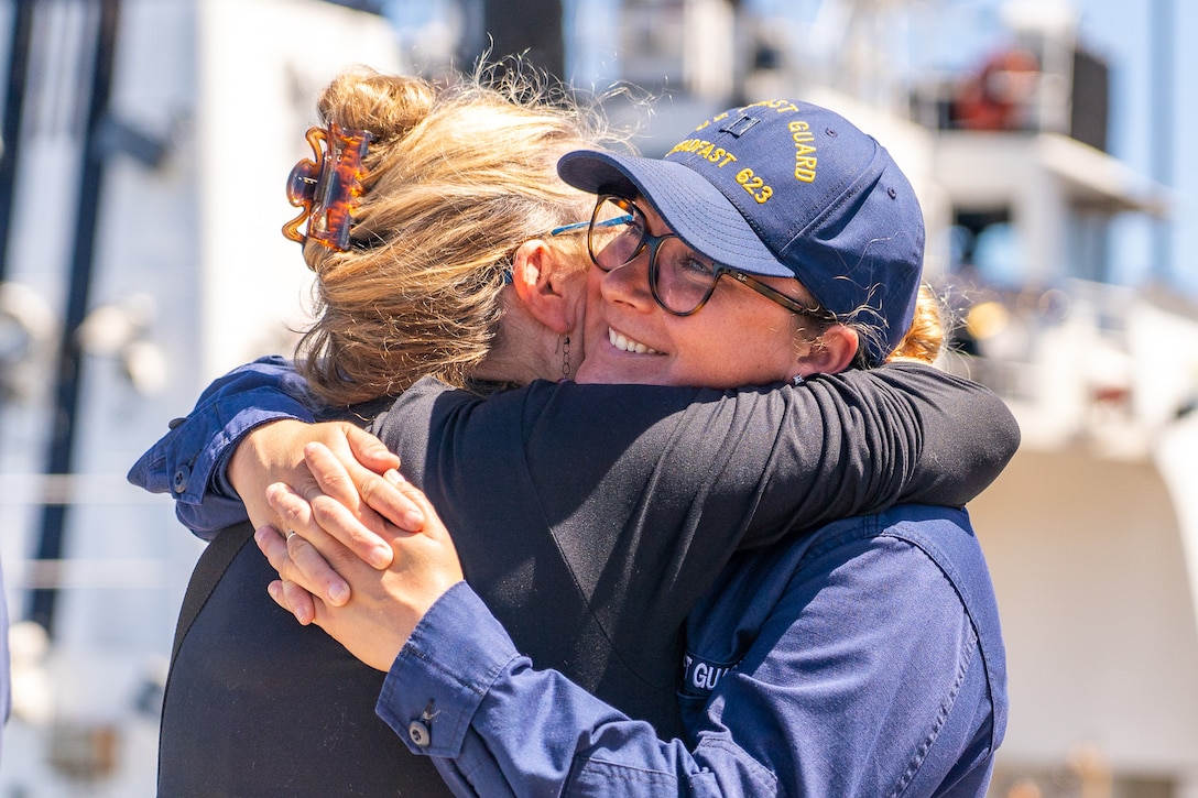 L.t. Cecelia Hosley, the operations officer aboard USCGC Steadfast hugs a visitor after the cutter crew arrived back to their homeport in Astoria, Oregon, following a patrol July 21, 2023. Steadfast is a 210-foot reliance class cutter. (U.S. Coast Guard photo by Petty Officer 1st Class Travis Magee)