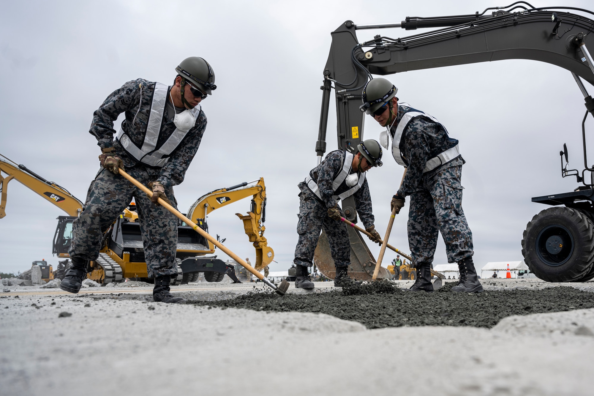 Japan Air Self-Defense Force Airmen fill a crater during a bilateral live fire exercise.