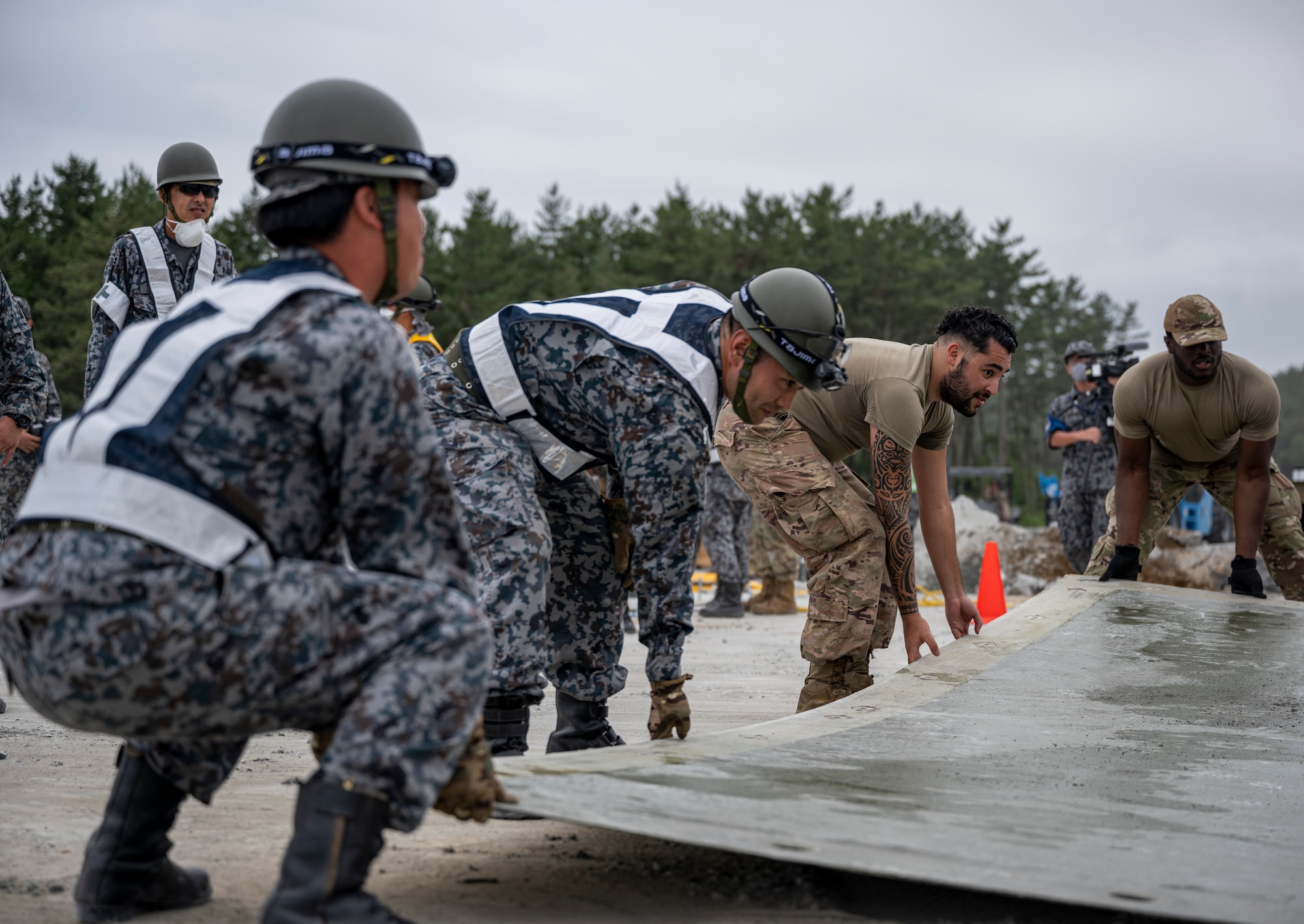 U.S. Air Force Airmen assigned to the 18th Civil Engineer Group and Japan Air Self-Defense Force Airmen assigned to the Western Air Civil Engineering Group set down a fiber-reinforced polymer (FRP) mat during a bilateral live fire exercise.