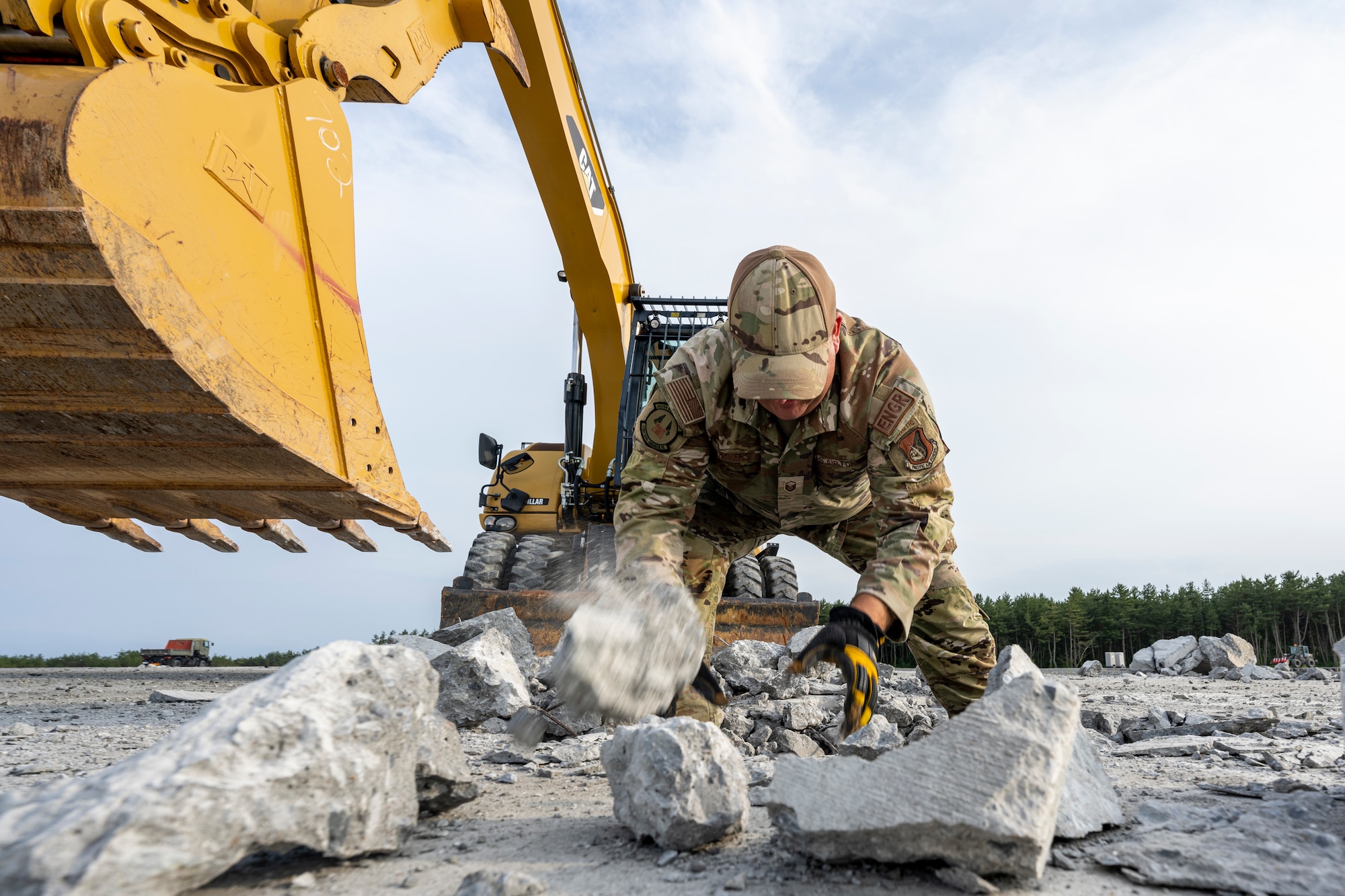 U.S. Air Force Airmen assigned to the 18th Civil Engineer Group remove concrete pieces inside a crater during a bilateral live fire exercise.