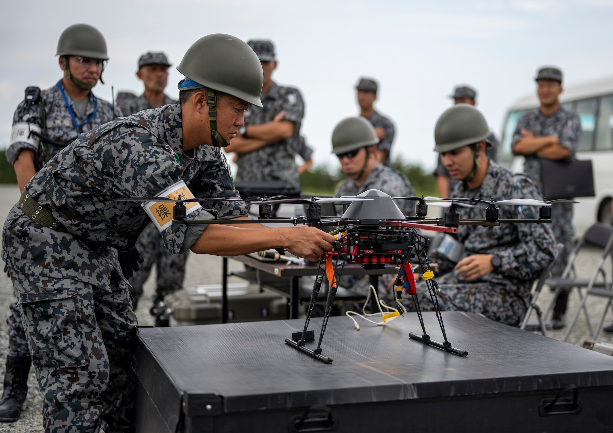 A Japan Air Self-Defense Force Airman assigned to the Western Air Civil Engineering Group sets up a drone during a bilateral live fire exercise.