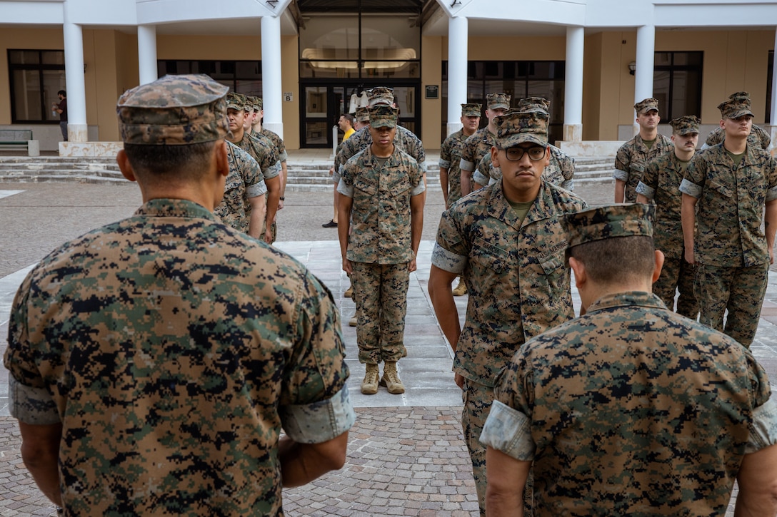 U.S. Marines with 2nd Marine Expeditionary Brigade (2d MEB) stand at attention as U.S. Marine Corps Cpl. Eduardo Garcia, Data System Administrator, reenlistments under the Commandant’s Retention Program (CRP) at Naval Support Site (NSA) Naples, on July 21 2023. The CRP makes reenlisting much easier for selected Marines by expediting the reenlistment process, and offers them meaningful incentives to reenlist such as assignment prioritization, in order to help retain the most talented first term marines. (U.S. Marine Corps photo by Lance Cpl. Jack Labrador)