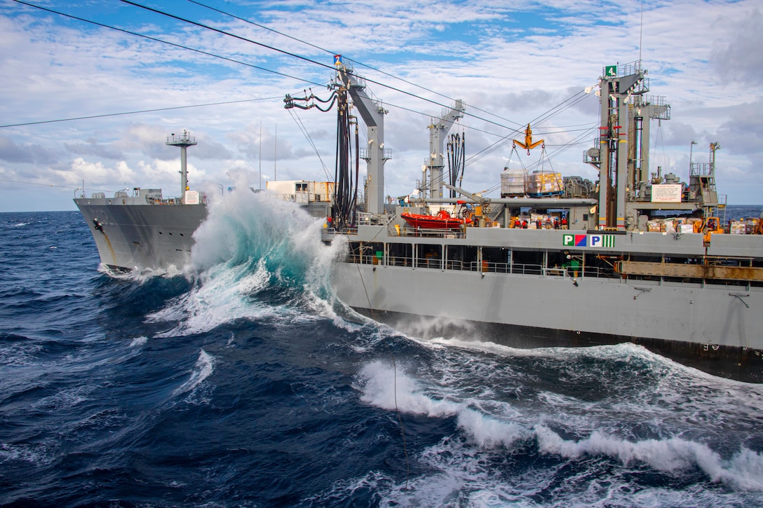 A large wave hits the side of a ship.