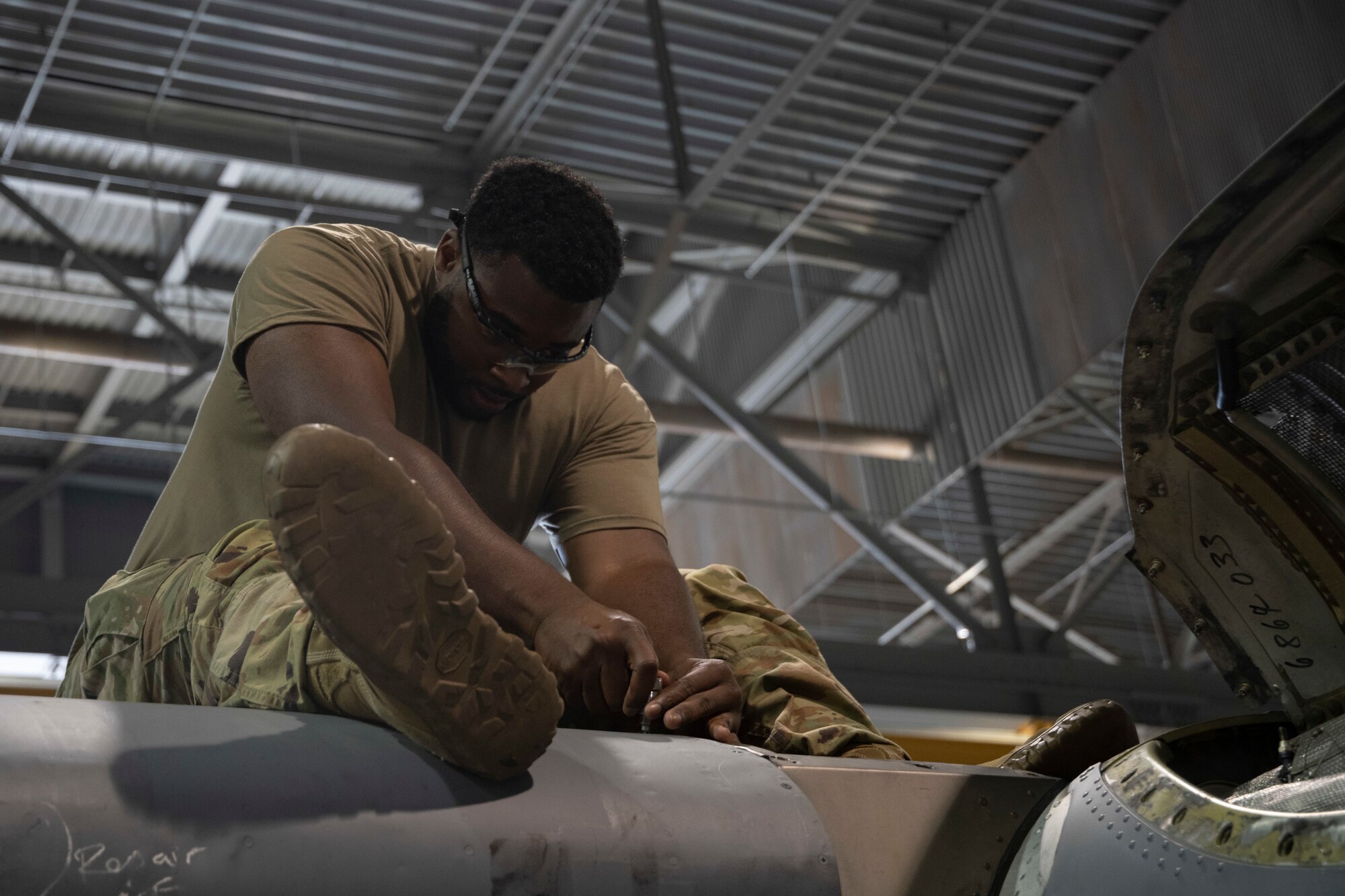 A man works on an aircraft frame.