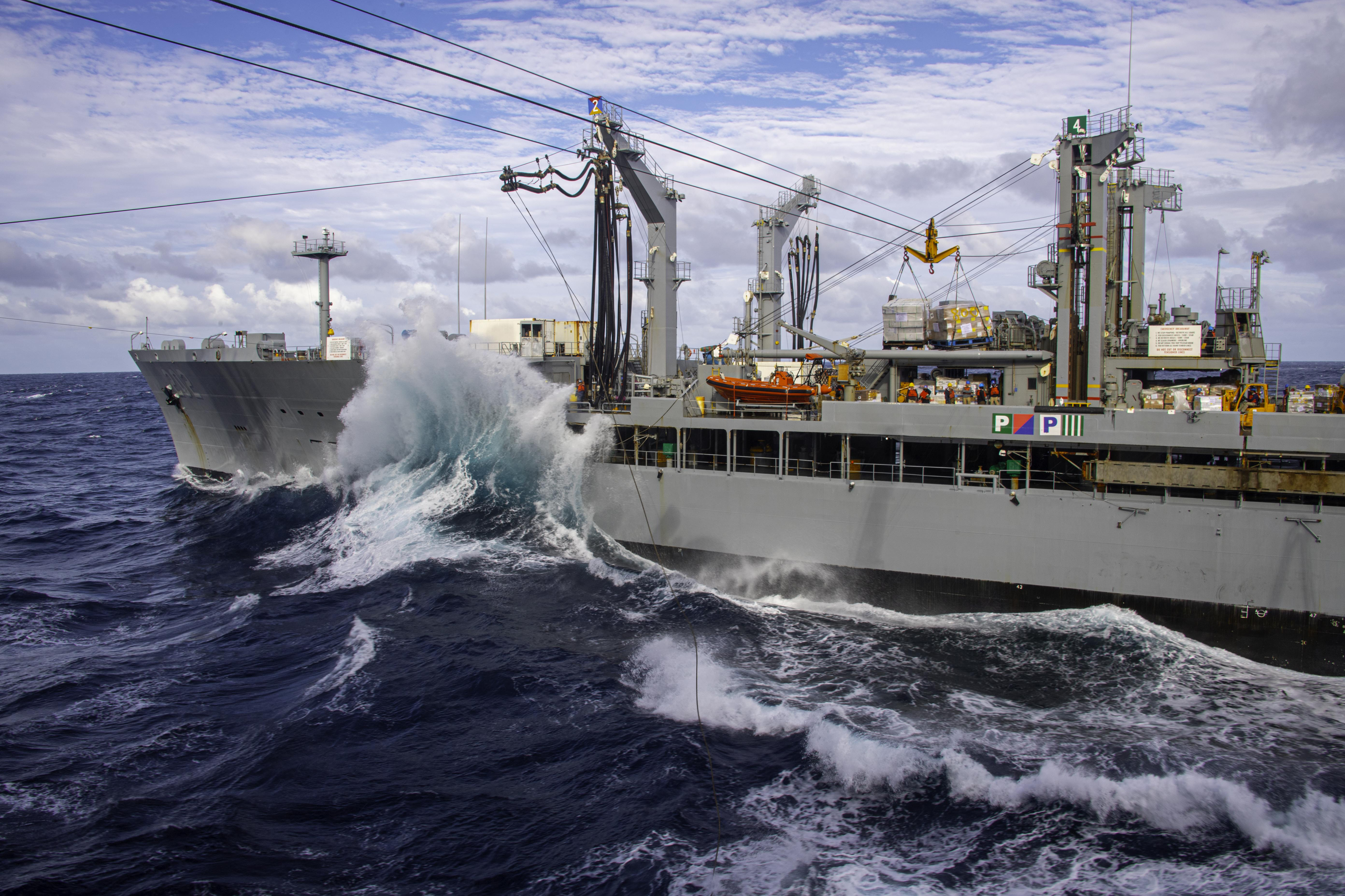 A large wave hits the side of a ship.