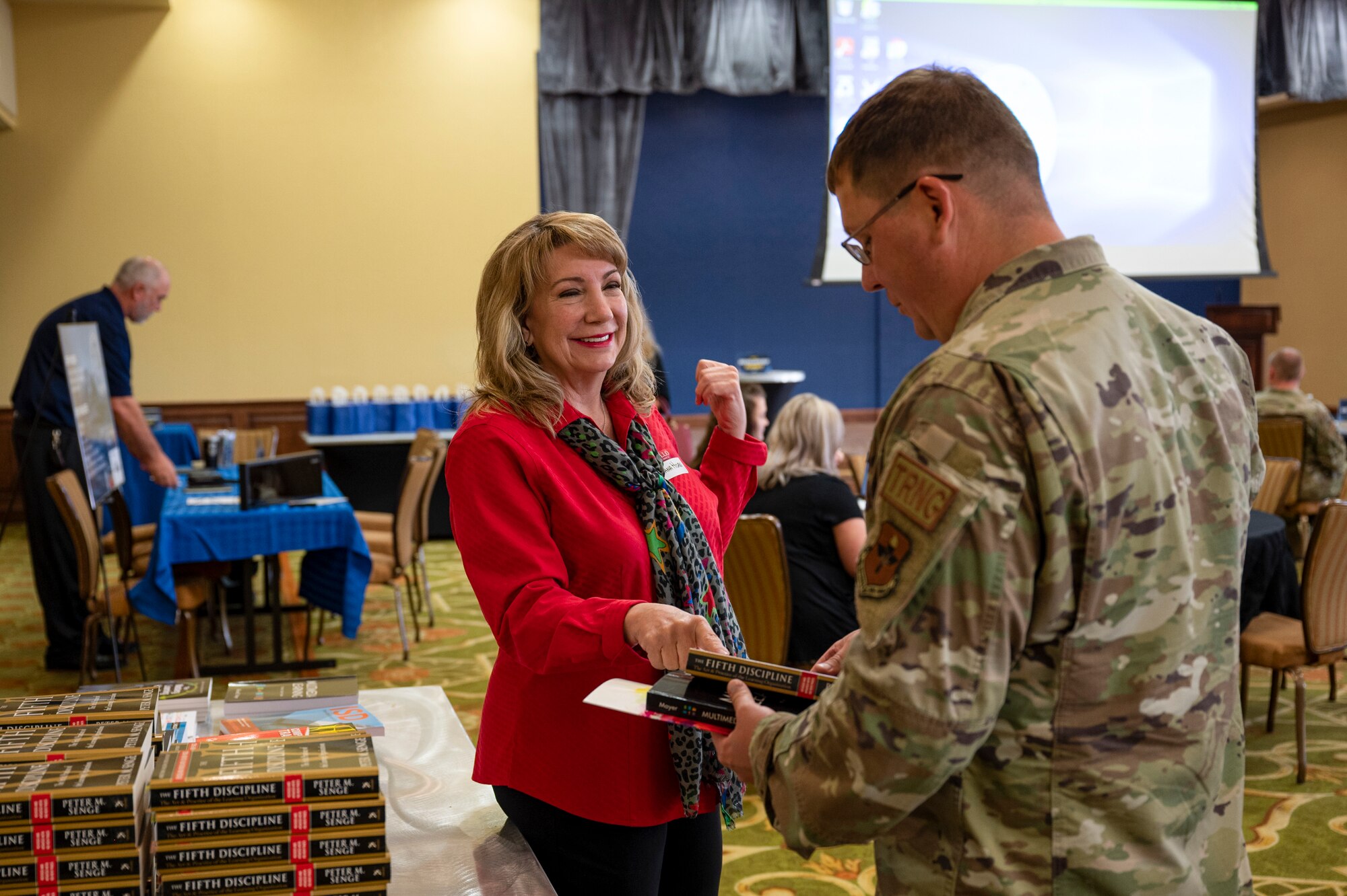 Dana Horn hands book to participant as they enter the Developers' Summit.