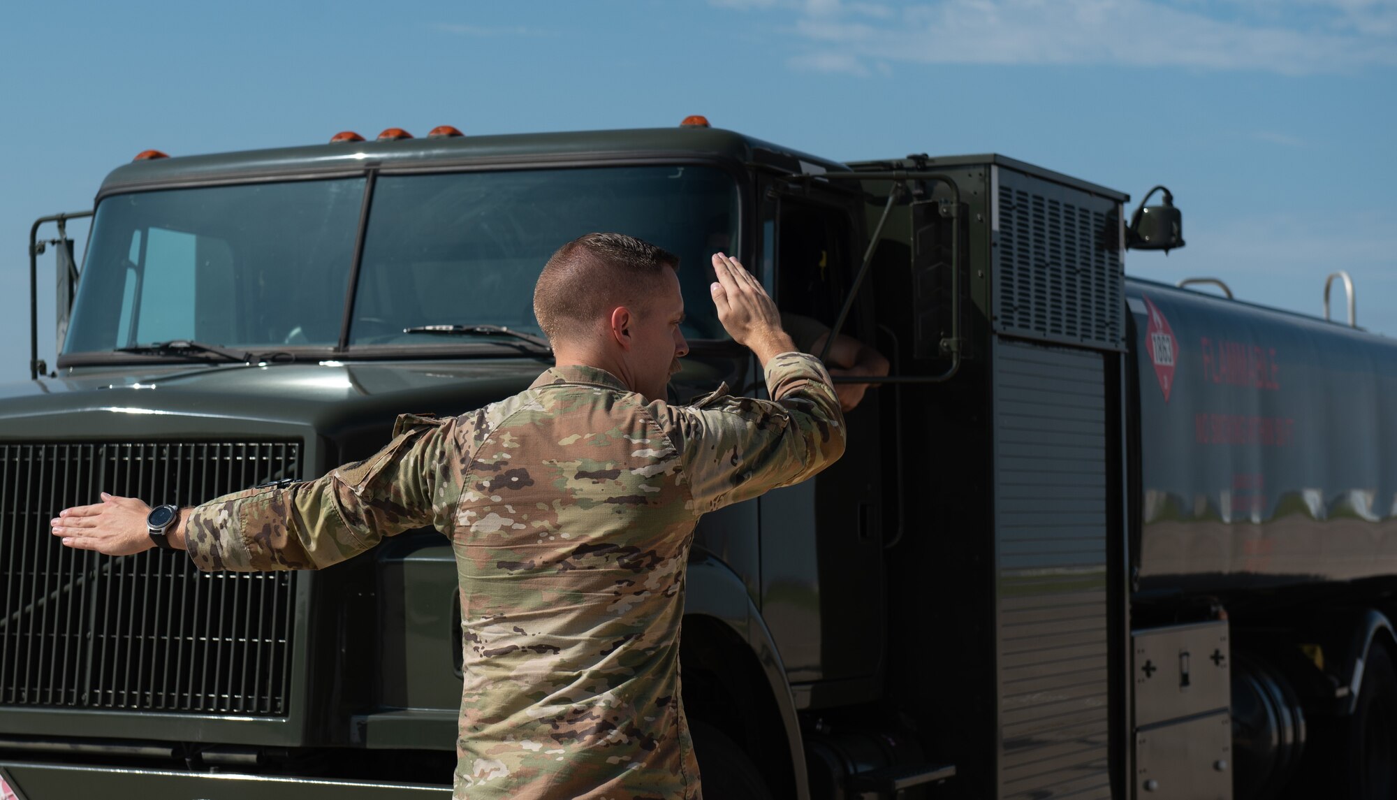Tech. Sgt. Cody Post, 22nd Logistic Readiness Squadron noncommissioned officer in charge of fuels distribution, marshals a fuels truck into place July 13, 2023, at McConnell Air Force Base, Kansas. Post and other 22nd LRS Airmen hooked the truck up to a Versatile Integrating Partner Equipment Refueling (VIPER) kit, which can be used to fuel any aircraft in the world. (U.S. Air Force photo by Staff Sgt. Tryphena Mayhugh)