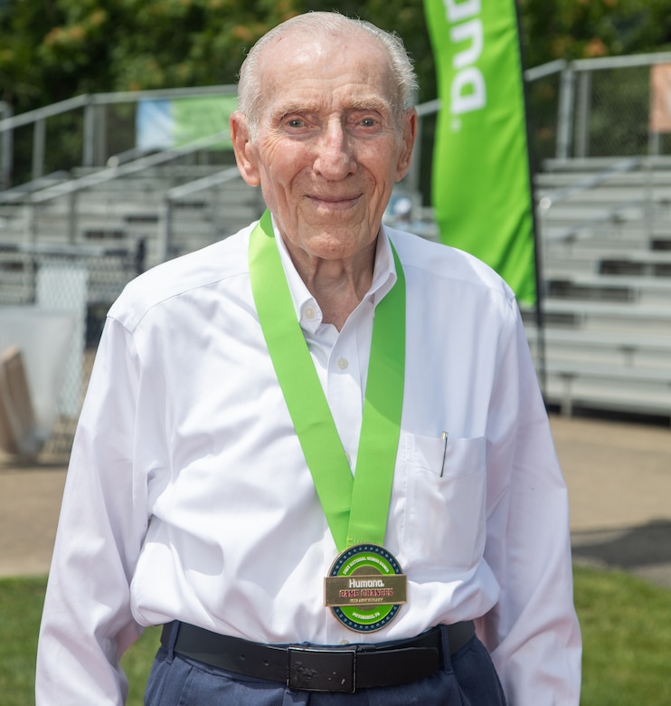 A man wears a gold medal around his neck.