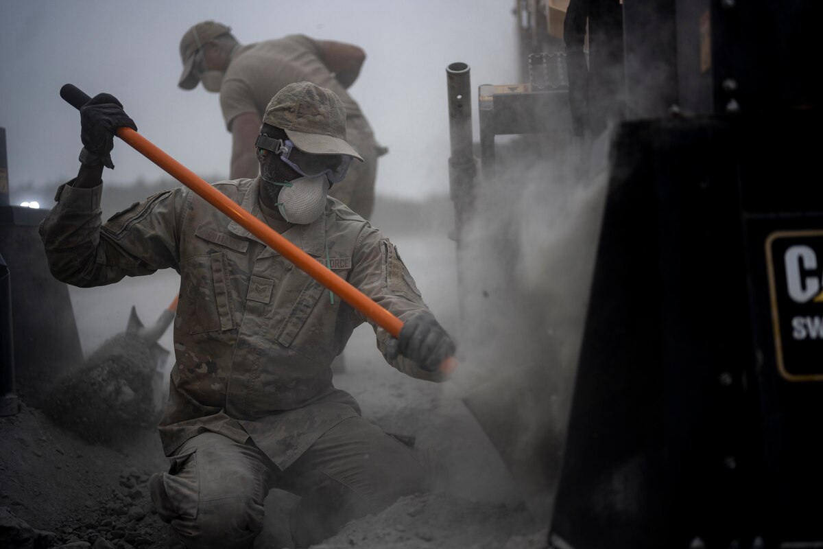 U.S. Air Force Airmen assigned to the 18th Civil Engineer Group remove concrete residue from heavy machinery during a bilateral live fire exercise.