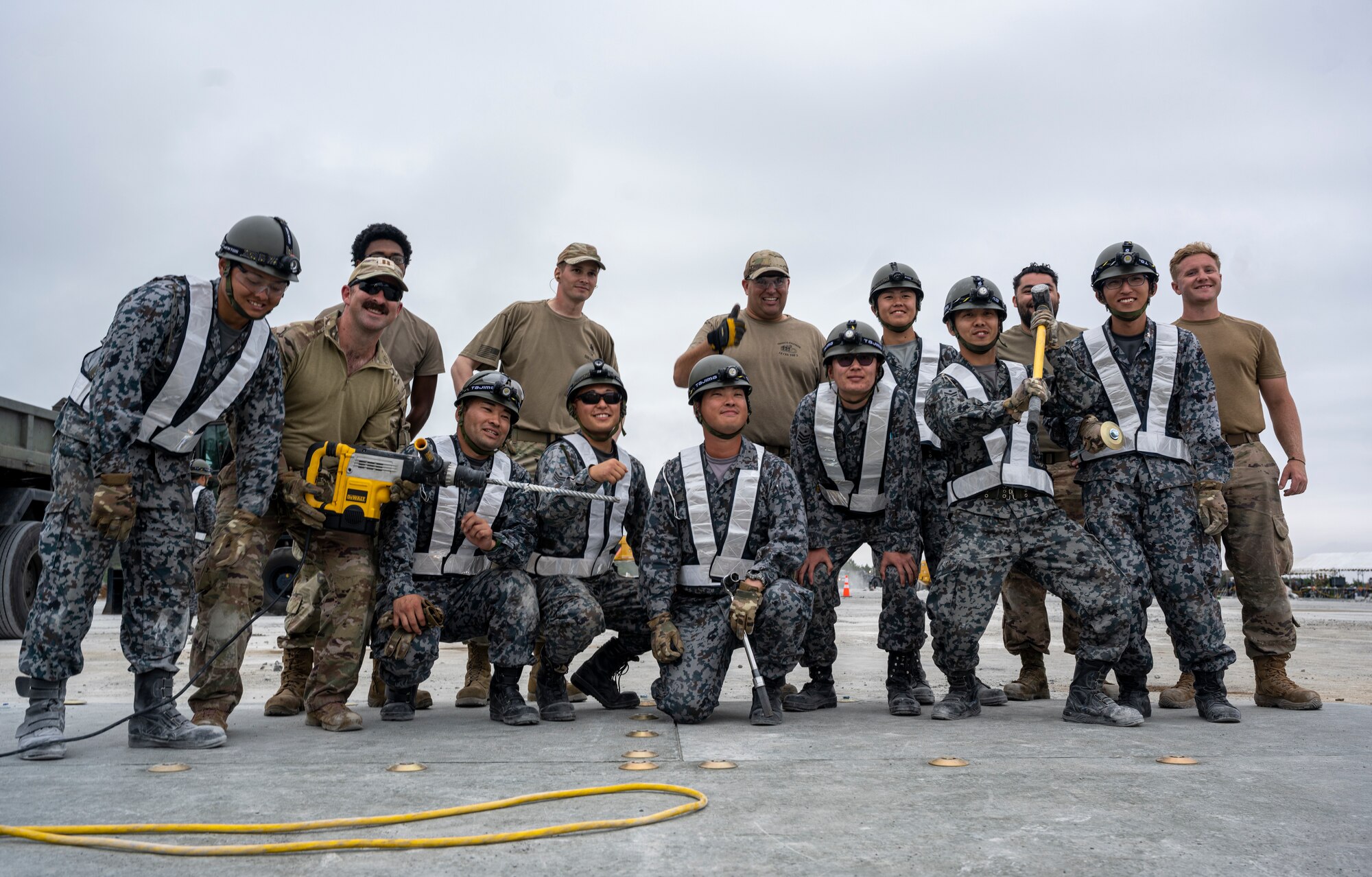 U.S. Air Force Airmen assigned to the 18th Civil Engineer Group and Japan Air Self-Defense Force Airmen assigned to the Western Air Civil Engineering Group pose for a group photo during a bilateral live fire exercise.