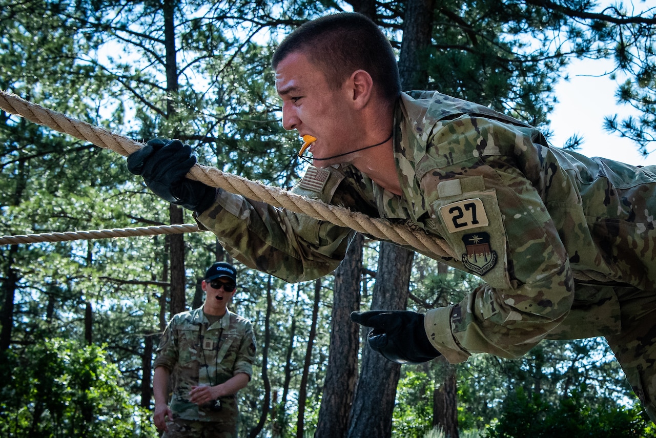 A cadet climbs a rope obstacle.