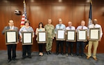 Naval Surface Warfare Center, Philadelphia Division (NSWCPD) Commanding Officer Capt. Joseph Darcy (center) presents NSWPCD personnel (pictured left to right holding awards) John Imbesi, Marie Nichols, Theresa Steck, James Brigham, Shawn Egnak, Douglas McDonnell, and Frederick Good with Career Service Awards for 40 years of service to the U.S. federal government during NSWCPD’s Fiscal Year (FY) 2023 Second Quarter Awards Ceremony on June 8, 2023. (U.S. Navy photo by Phillip Scaringi/Released)