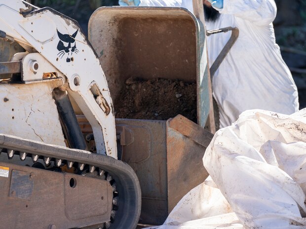 A Naval Facilities Engineering Systems Command (NAVFAC) Fleet Logistics Center (FLC) Pearl Harbor employee rolls a wheelbarrow of contaminated soil to a tractor as part of NAVFAC Public Works Department and Joint Task Force-Red Hill’s (JTF-RH) hazard material spill recovery operation at the Red Hill Bulk Fuel Storage Facility (RHBFSF) in Halawa, Hawaii, Dec. 2, 2022. Remediation of the spill site through excavation and removal of contaminated surfaces and material was immediately initiated after an estimated 1,100 gallons of aqueous film forming foam (AFFF) concentrate spilled from the fire suppression system at RHBFSF Adit 6 on Nov. 29, 2022. JTF-RH was established by the Department of Defense to ensure the safe and expeditious defueling of the RHBFSF. (DoD photo by Staff Sgt. Orlando Corpuz)