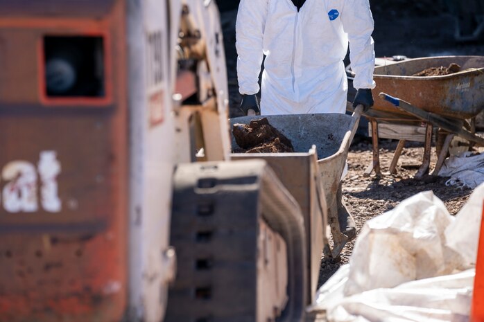 A Naval Facilities Engineering Systems Command (NAVFAC) Fleet Logistics Center (FLC) Pearl Harbor employee rolls a wheelbarrow of contaminated soil to a tractor as part of NAVFAC Public Works Department and Joint Task Force-Red Hill’s (JTF-RH) hazard material spill recovery operation at the Red Hill Bulk Fuel Storage Facility (RHBFSF) in Halawa, Hawaii, Dec. 2, 2022. Remediation of the spill site through excavation and removal of contaminated surfaces and material was immediately initiated after an estimated 1,100 gallons of aqueous film forming foam (AFFF) concentrate spilled from the fire suppression system at RHBFSF Adit 6 on Nov. 29, 2022. JTF-RH was established by the Department of Defense to ensure the safe and expeditious defueling of the RHBFSF. (DoD photo by Staff Sgt. Orlando Corpuz)