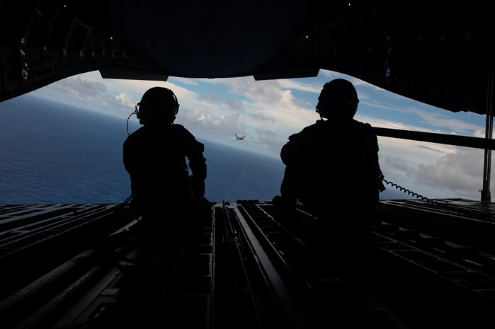 Royal Australian Air Force Corporal Charlotte Roe, a  C-17 Globemaster III Loadmaster assigned to No. 36 Squadron RAAF in Base Amberley, Australia, left, and U.S. Air Force Master Sgt Jason Livingston, a C-17 Loadmaster assigned to 16 Airlift Squadron in Joint Base Charleston, SC, right, watch as a U.S. C-17 from the 62nd Airlift Wing in Joint Base Lewis-McChord, Washington, flies behind a RAAF C-17 from No. 36 SQN over the Commonwealth of the Northern Mariana Islands during exercise Mobility Guardian 23, July 12, 2023. MG23 is an opportunity to train alongside our Allies and partners to demonstrate interoperability and bolster our collective ability to support a free and open Indo-Pacific. (U.S. Air Force photo by Tech. Sgt. Sean Carnes)
