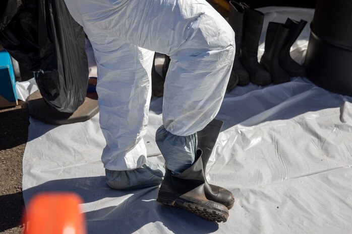 A Naval Facilities Engineering Systems Command (NAVFAC) Fleet Logistics Center (FLC) Pearl Harbor employee dons personal protective equipment before entering the spill site as part of NAVFAC Public Works Department and Joint Task Force-Red Hill’s (JTF-RH) hazard material spill recovery operation at the Red Hill Bulk Fuel Storage Facility (RHBFSF) in Halawa, Hawaii, Dec. 1, 2022. Remediation of the spill site through excavation and removal of contaminated surfaces and material was immediately initiated after an estimated 1,100 gallons of aqueous film forming foam (AFFF) concentrate spilled from the fire suppression system at RHBFSF Adit 6 on Nov. 29, 2022. JTF-RH was established by the Department of Defense to ensure the safe and expeditious defueling of the RHBFSF. (DoD photo by Spc. Matthew Mackintosh)